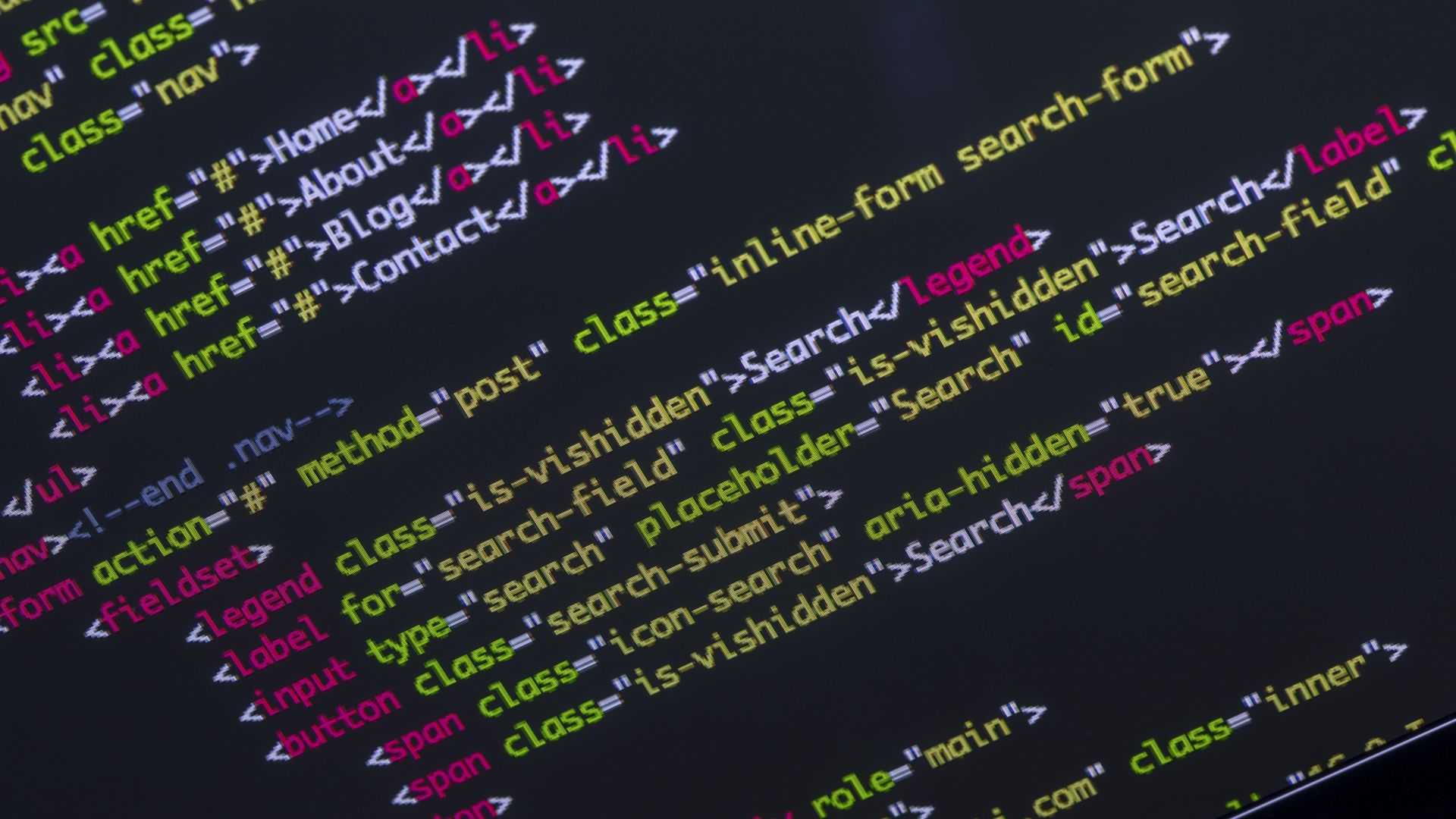 In this image, strings of multicolored code are displayed on a black computer screen.