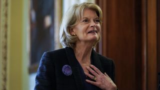 Sen. Lisa Murkowski (R-AK) speaks with a security guard as she stands outside the Senate Chamber on Capitol Hill on November 3, 2021 in Washington, DC.