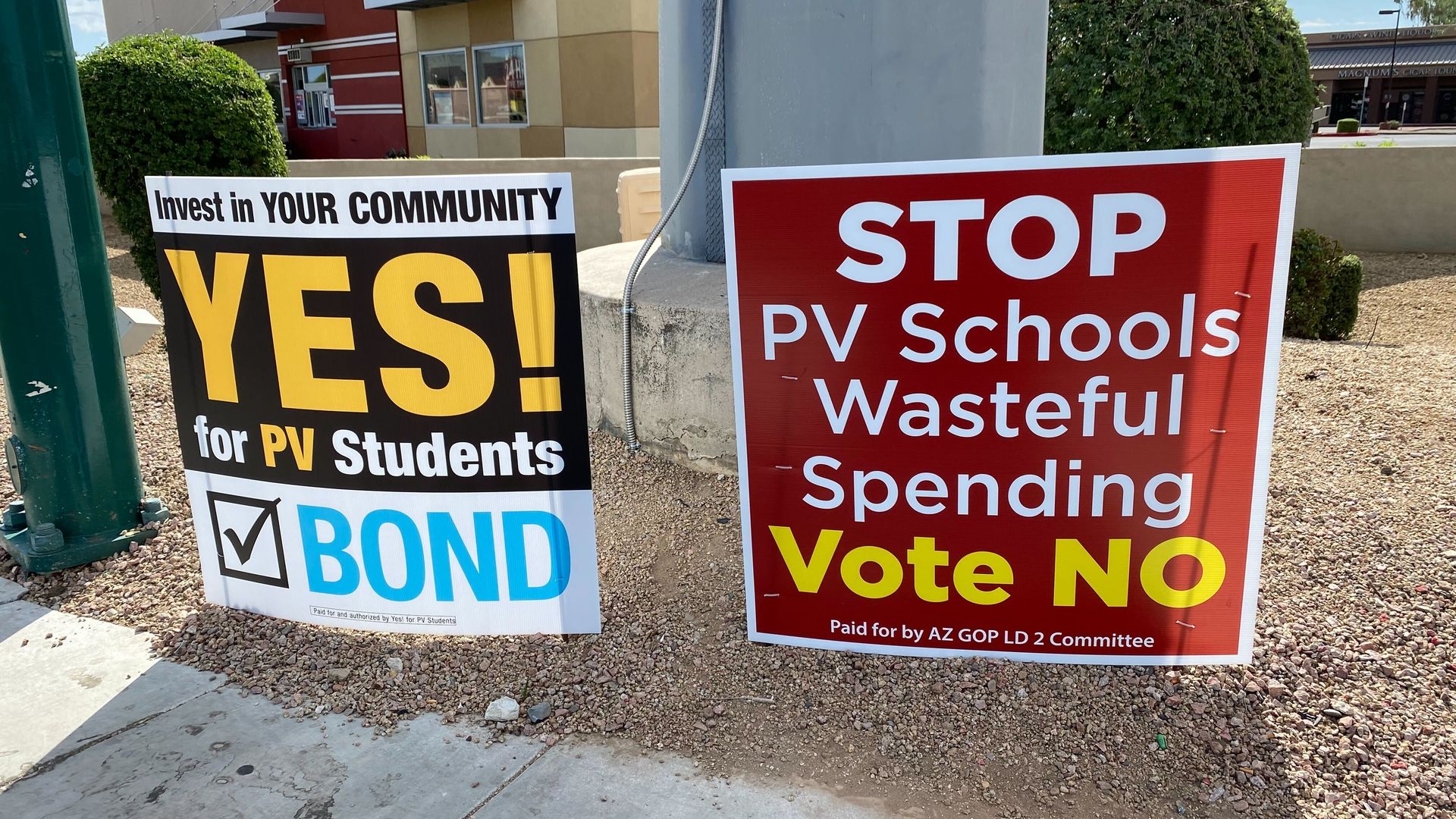 Two campaign signs - one encouraging a yes vote on a school bond election and the other encouraging a no vote. 