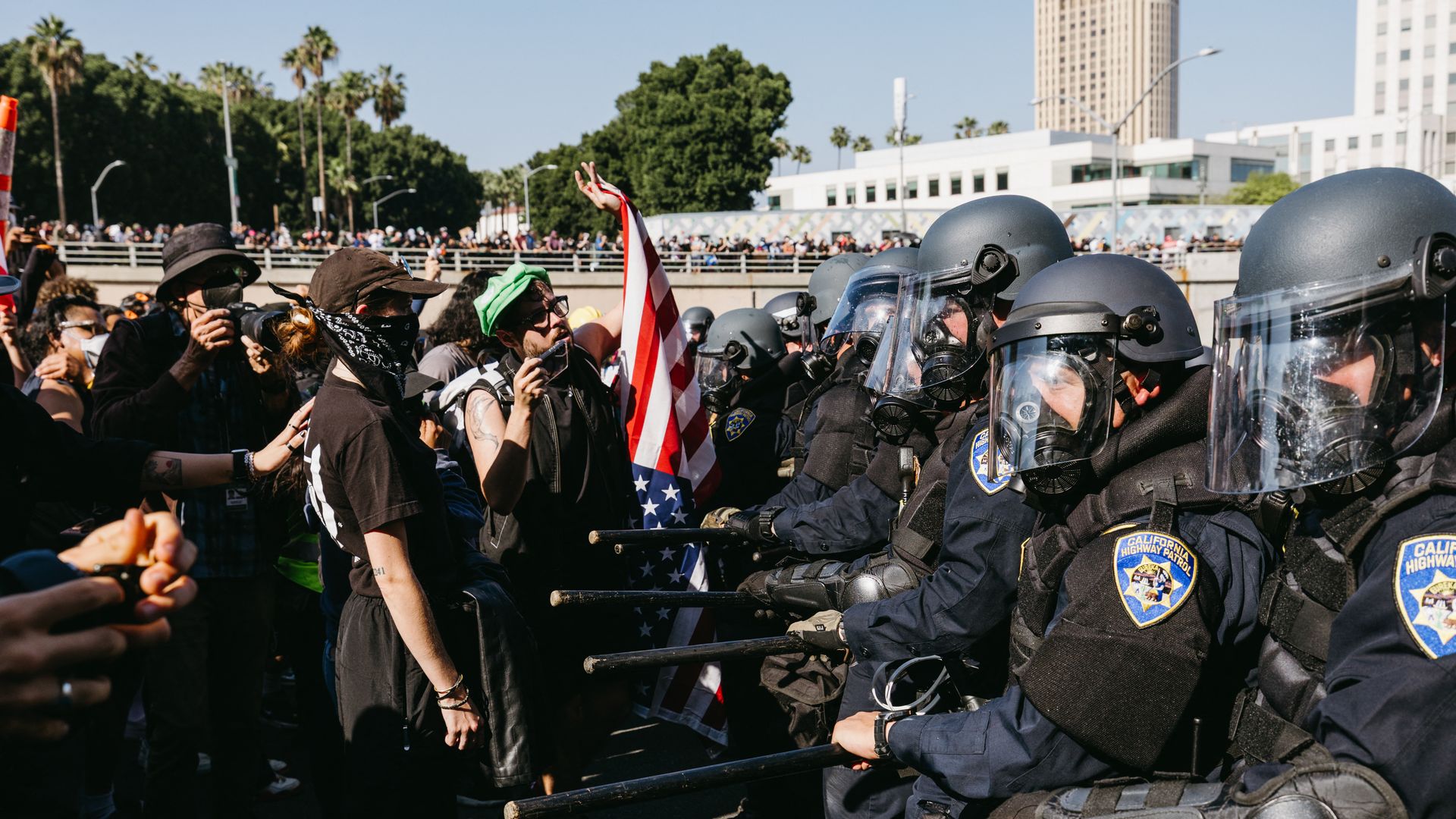 Protesters stand close to law enforcement officers wearing uniforms and helmets