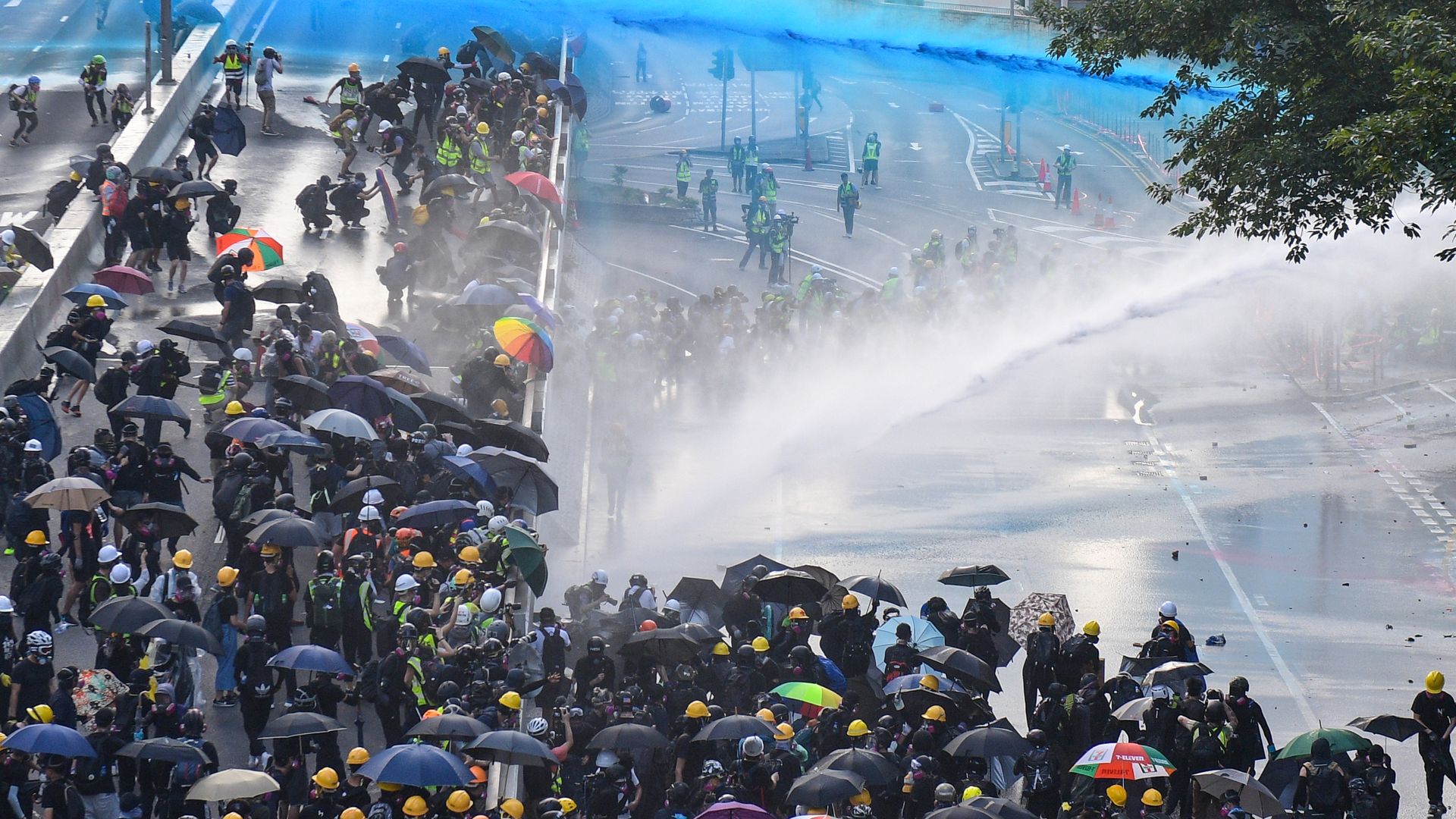 Pro-democracy protesters react as police fire water cannons outside the government headquarters in Hong Kong on September 15