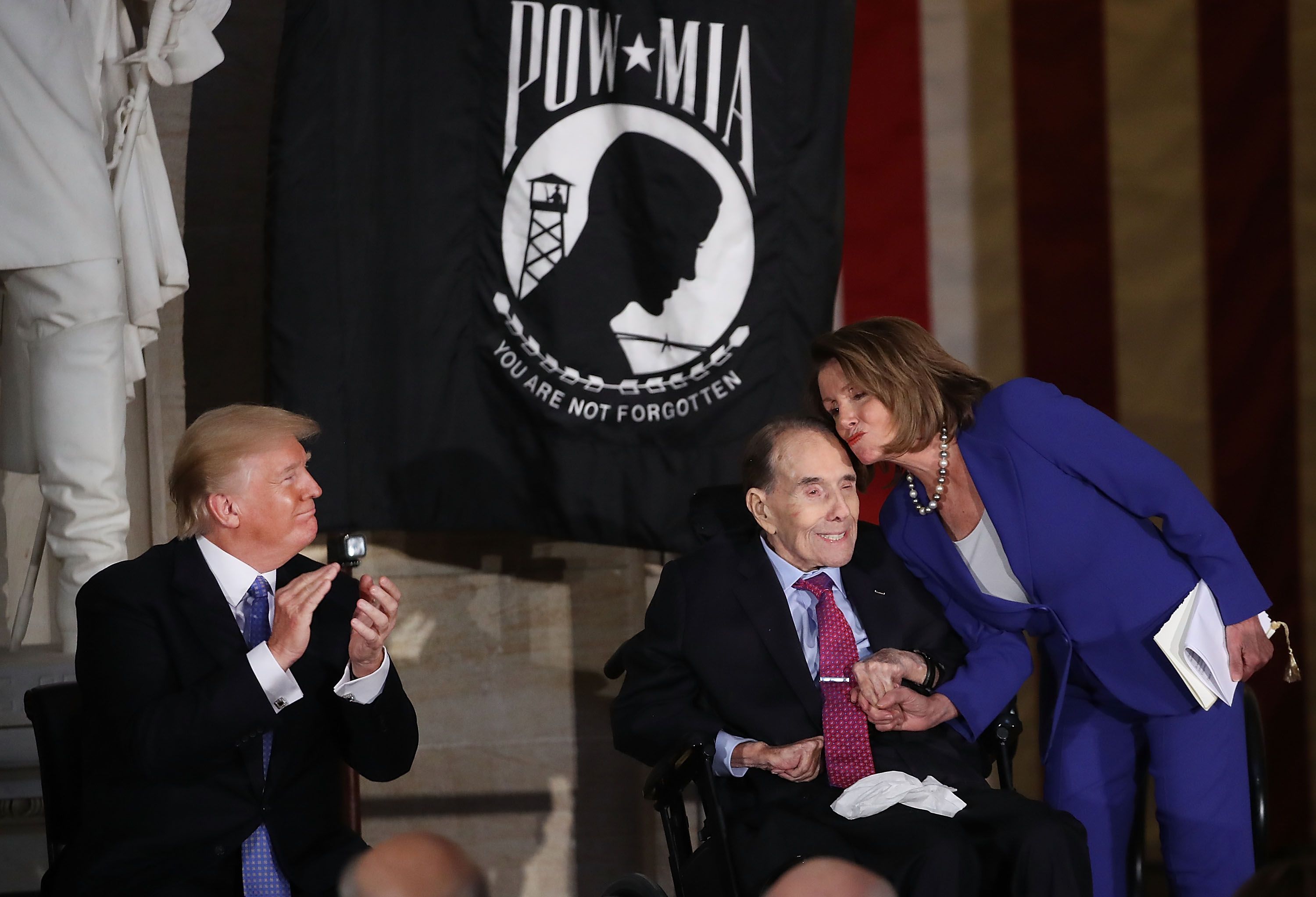 House Minority Leader Nancy Pelosi kisses former Senate Majority Leader Bob Dole 