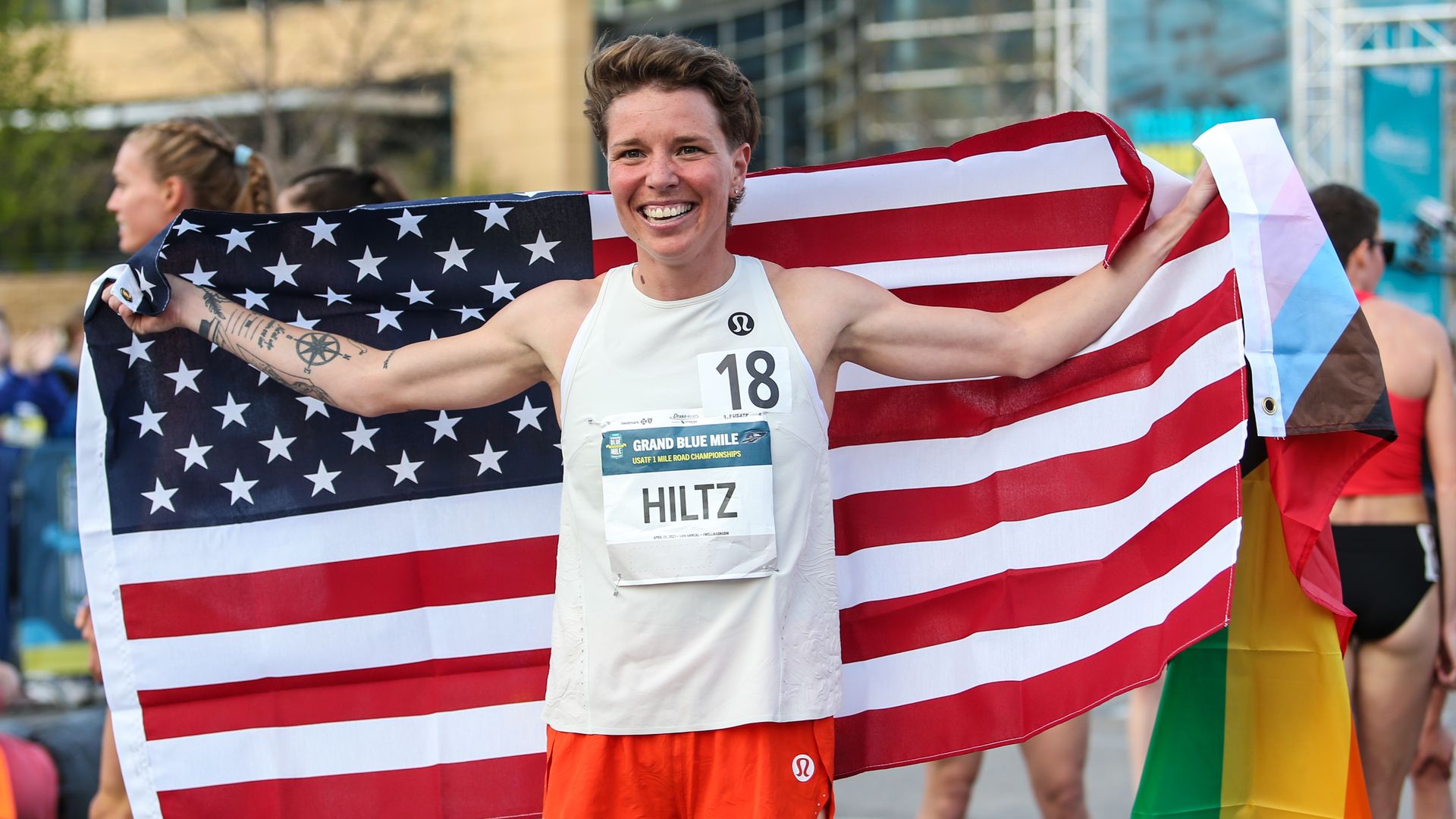 Nikki Hiltz with a U.S. and rainbow flag