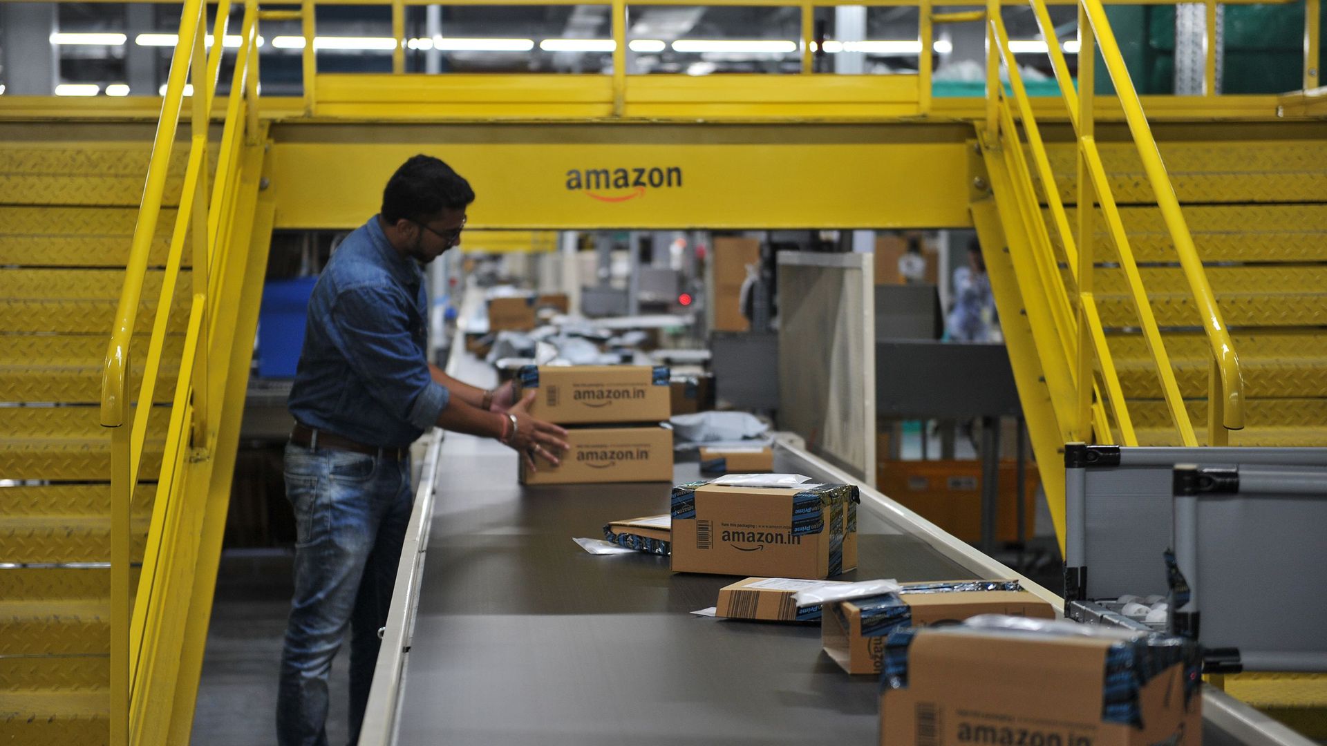 Man checks boxes marked for shipping on an assembly line