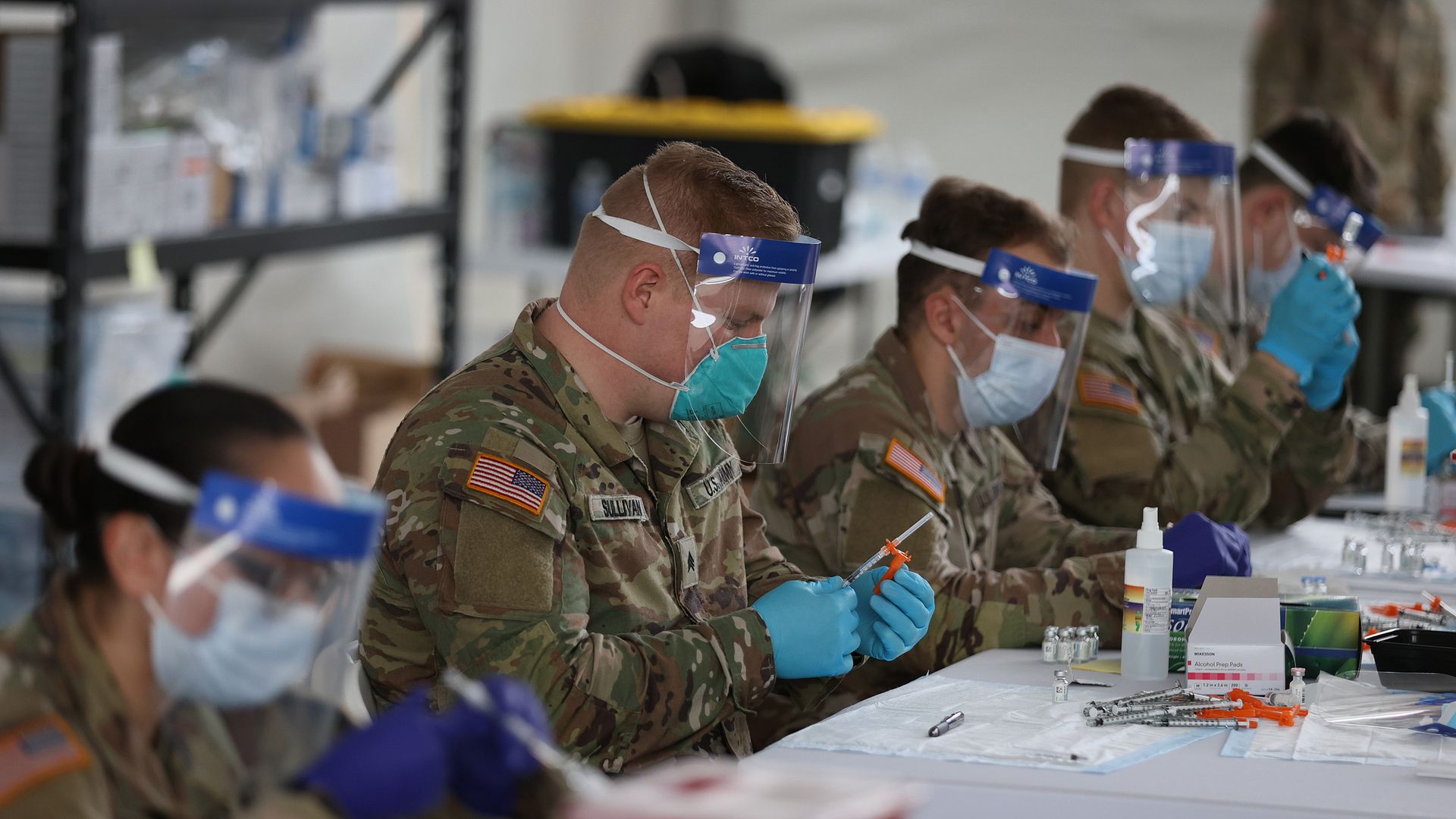 U.S. Army soldiers from the 2nd Armored Brigade Combat Team, 1st Infantry Division, prepare Pfizer COVID-19 vaccines to inoculate people at the Miami Dade College North Campus on March 10, 2021