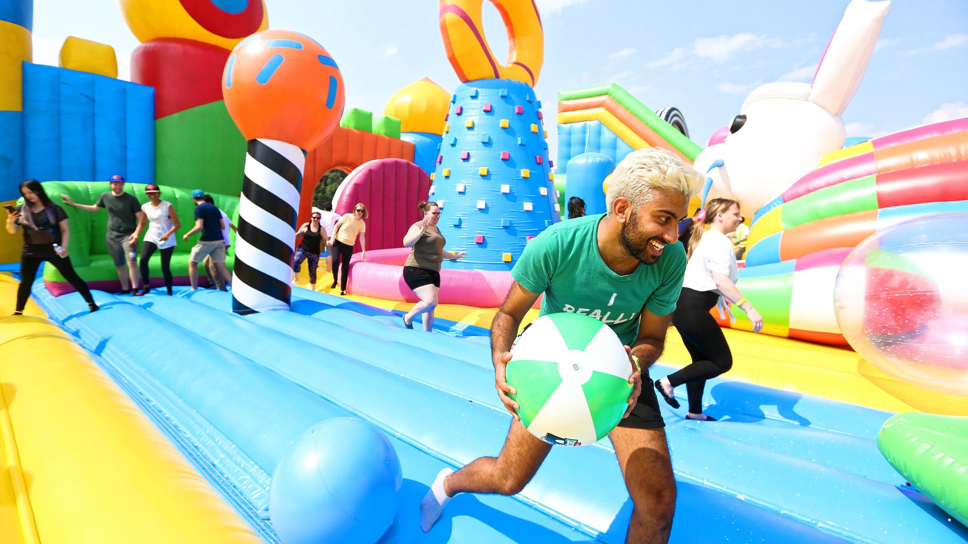 Adults playing in a bounce house.