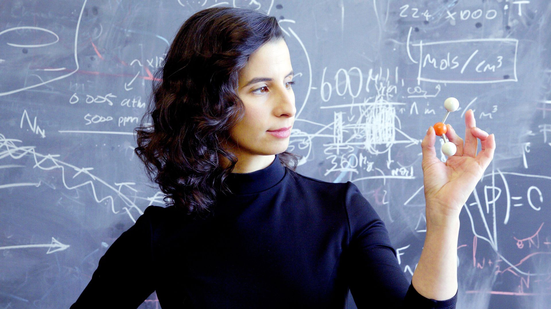 Dr. Clara Sousa-Sliva looking at a model of a phosphine molecule