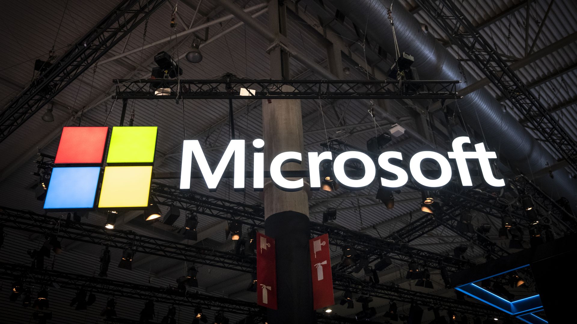 In this image, the Microsoft logo hangs in a warehouse. 