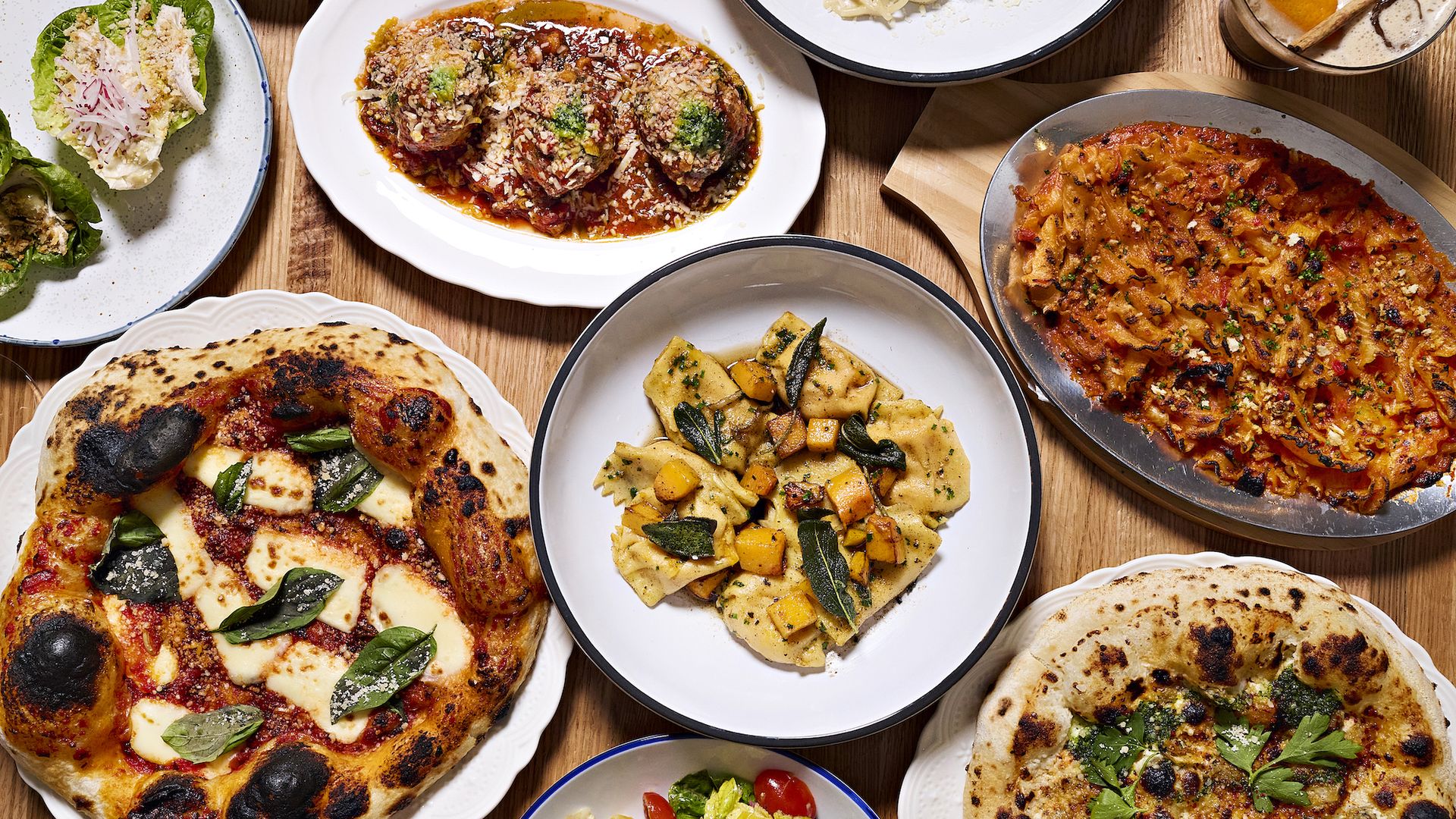 A table full of pasta, pizza and Italian dishes at Elena James