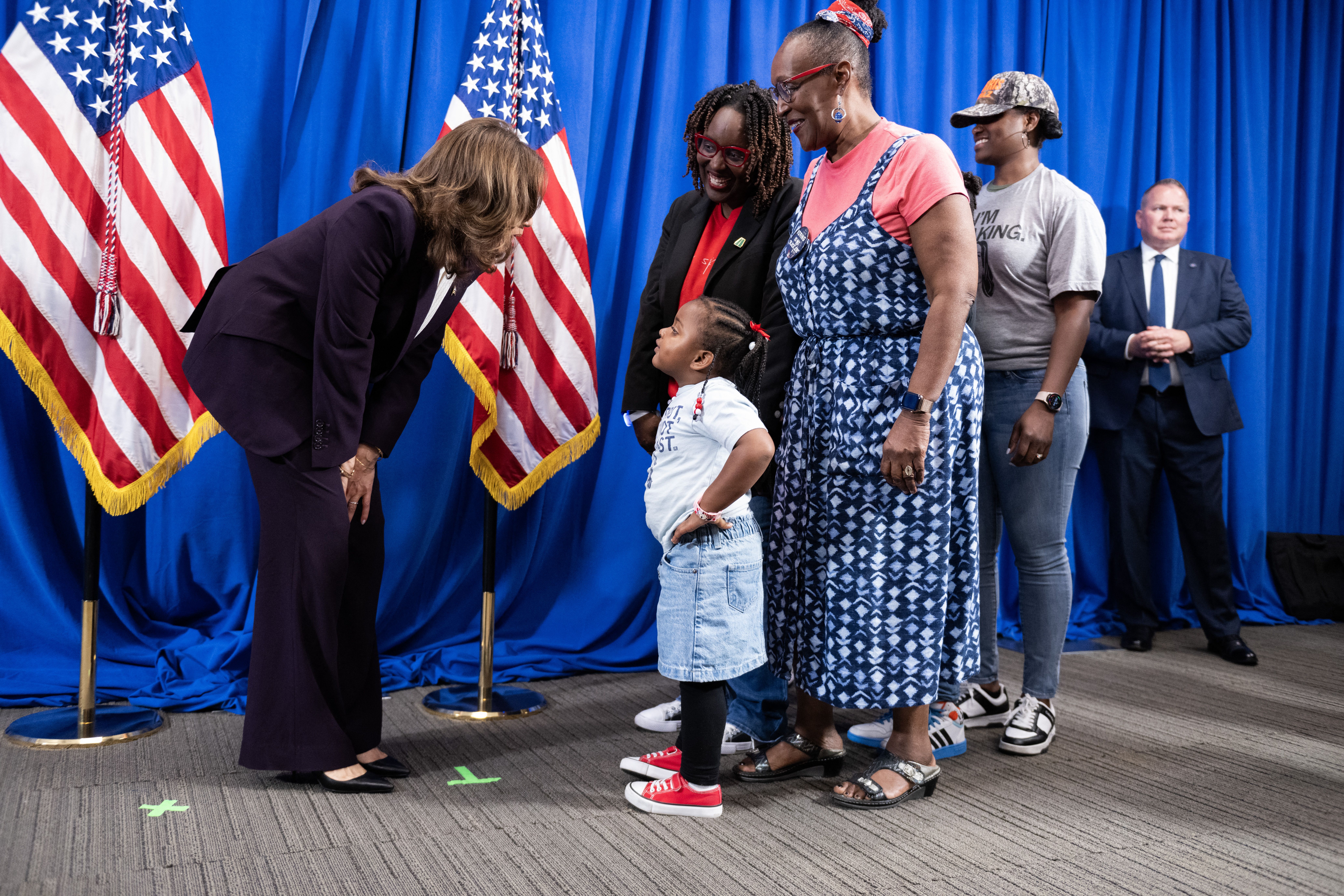 TOPSHOT - US Vice President and Democratic presidential candidate Kamala Harris looks at four-year-old Isabella Ward, who in the company of her family greeted Harris back stage before she was due to speak, during a campaign rally at Shell Energy Stadium in Houston