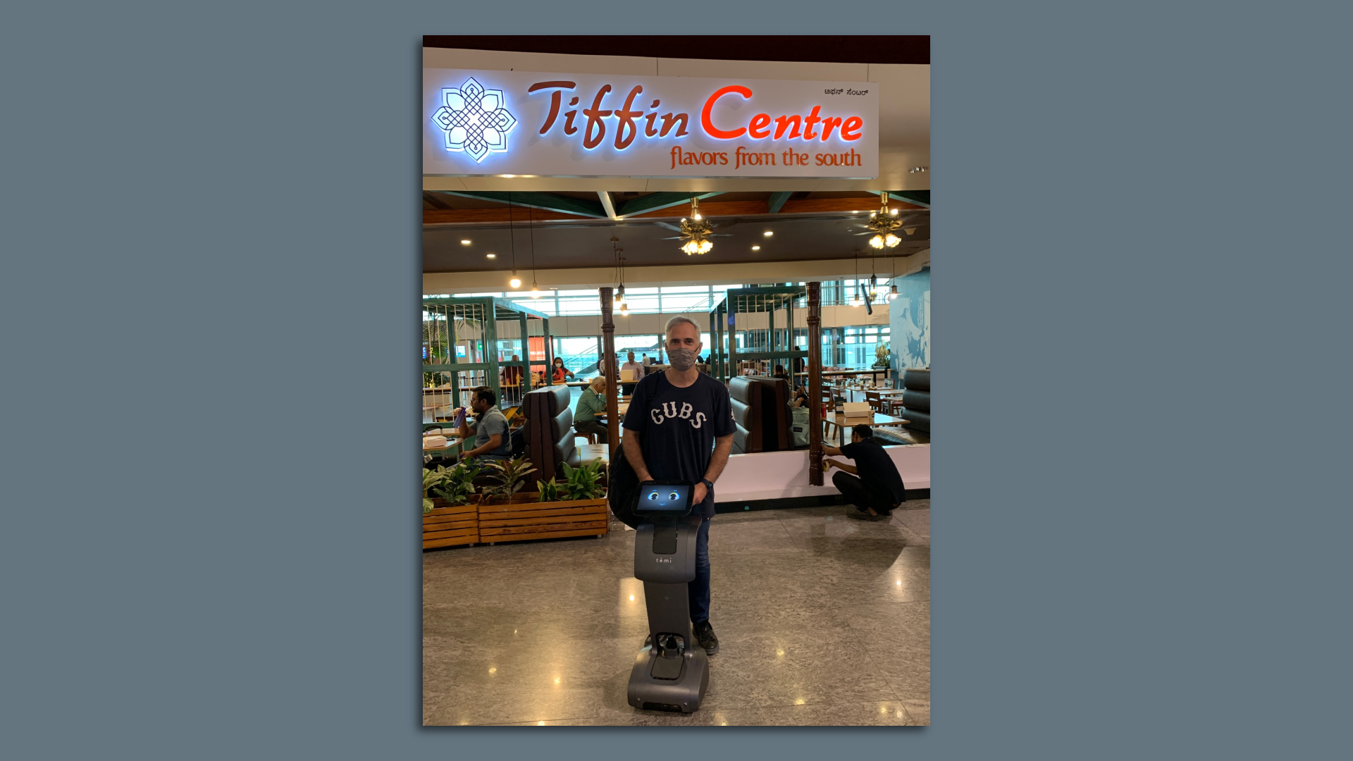 Reader Steve Okun with a direction-giving robot at the Bangalore airport.