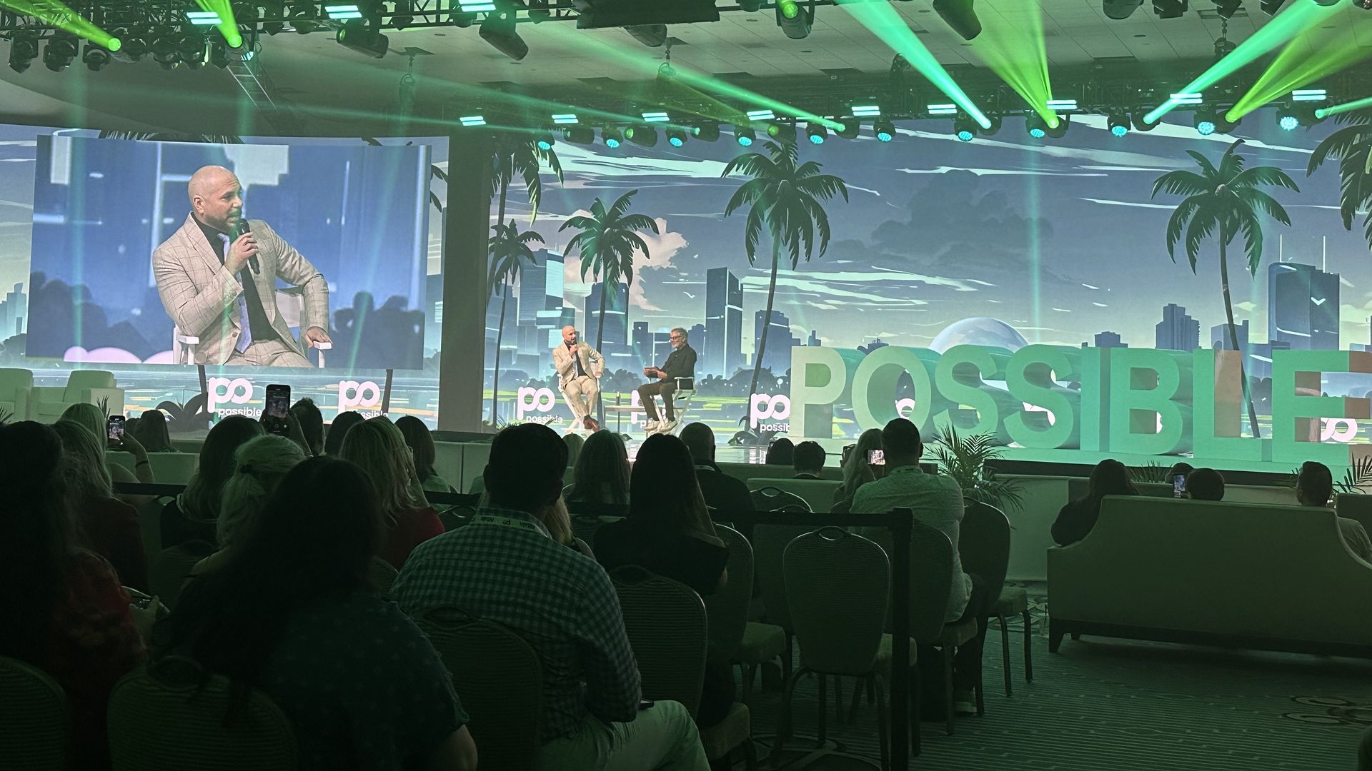 Pitbull and iHeartMedia CEO Bob Pittman onstage next to a giant sign that says POSSIBLE