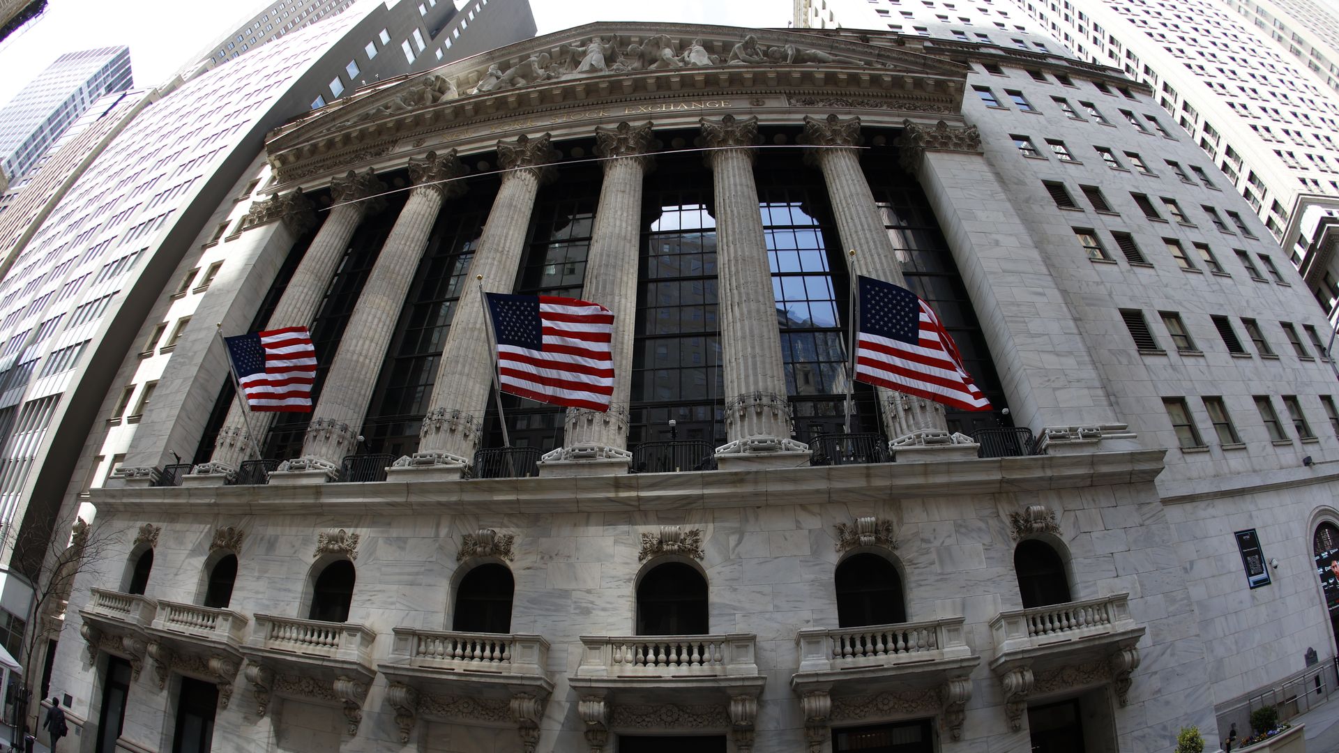 A stately looking building with pillars and American flags