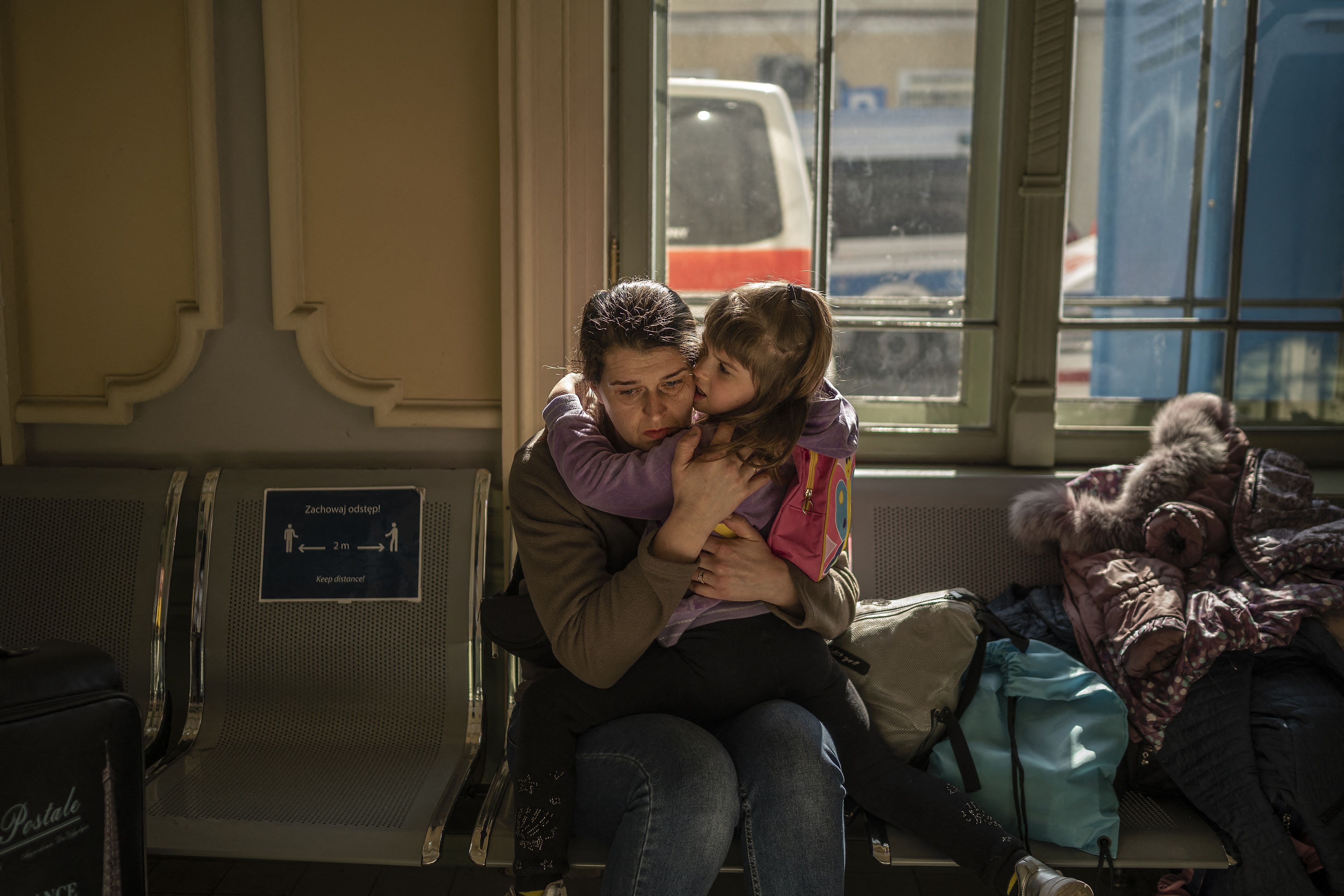 A Ukrainian evacuee hugs a child in the train station in Przemysl, near the Polish-Ukrainian border, on March 22, 2022.