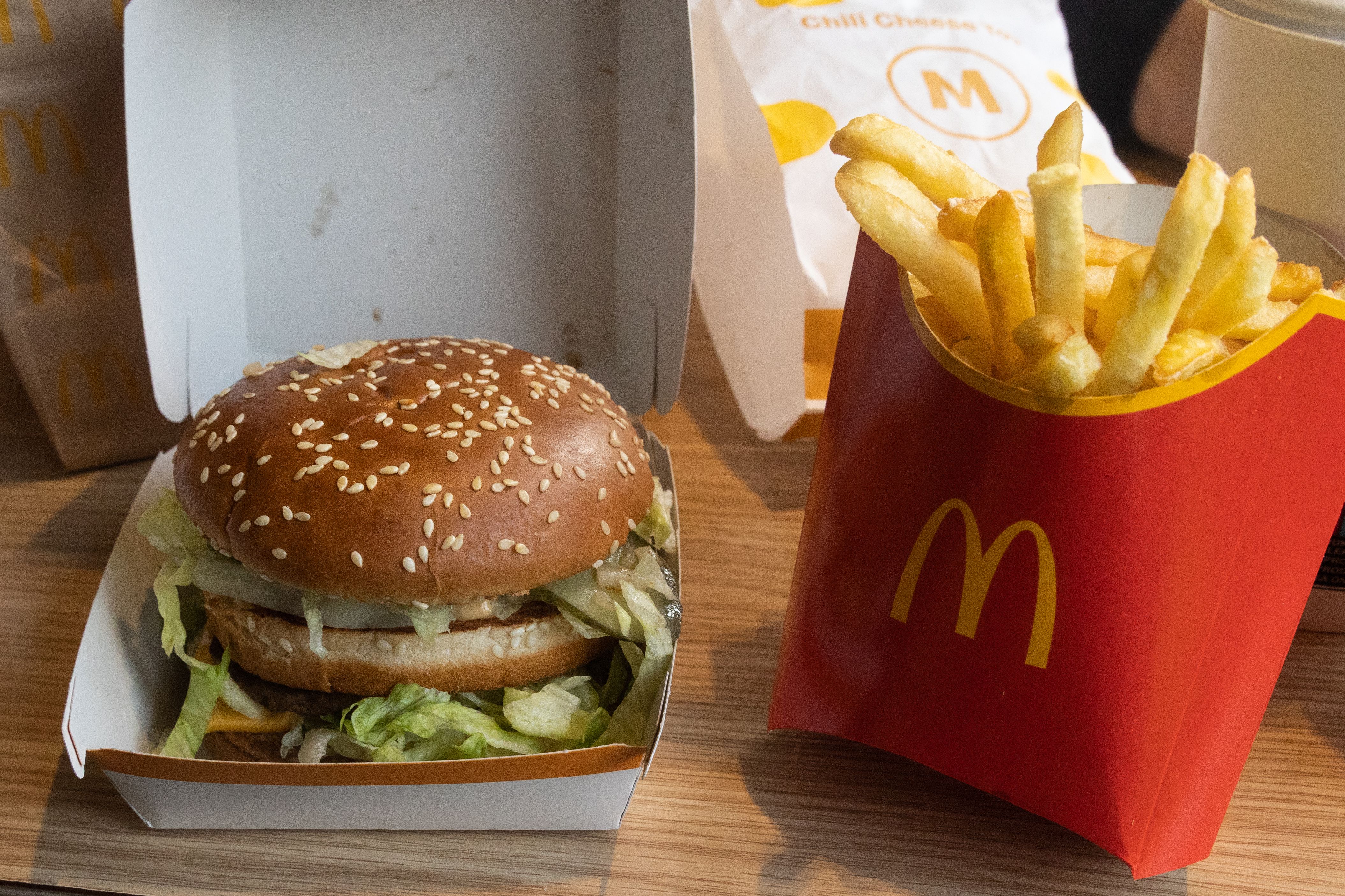Photo of a burger and fries on a table with red M packaging. 