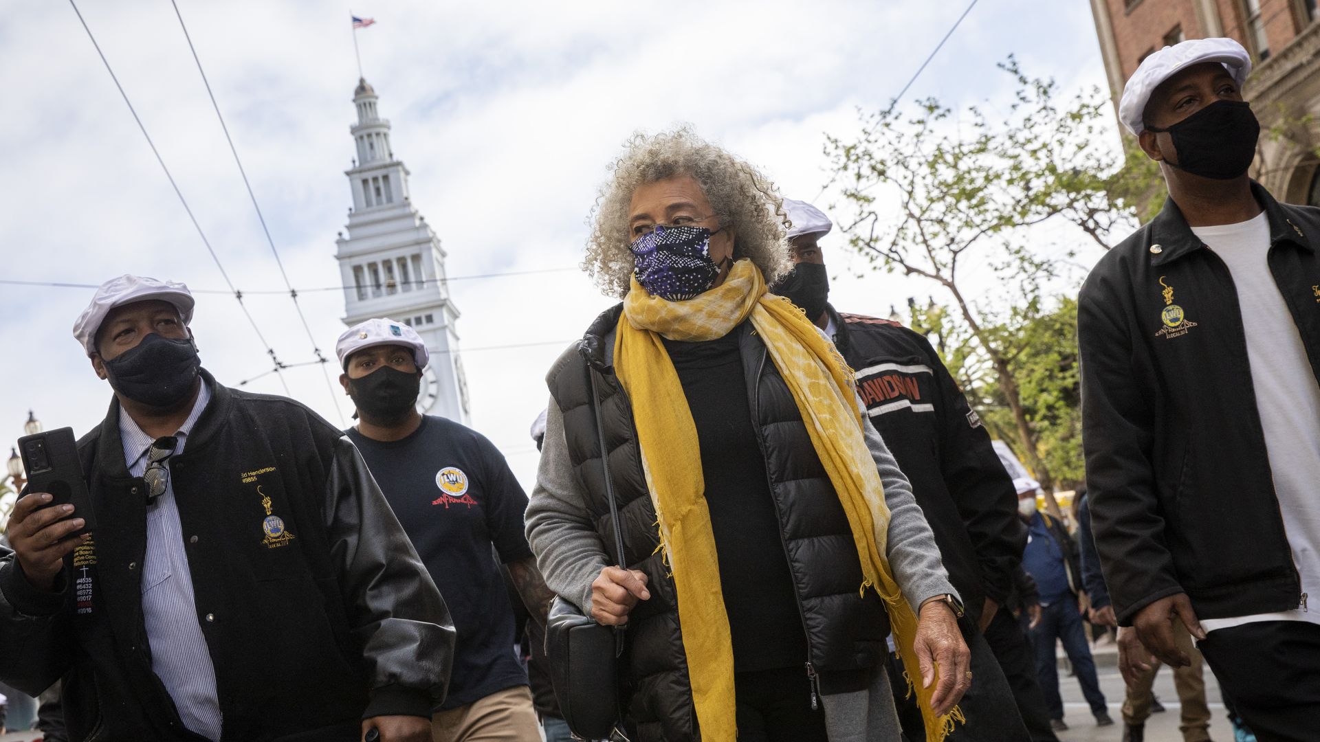 Photo of Angela Davis flanked by other labor activists in front of the San Francisco City Hall
