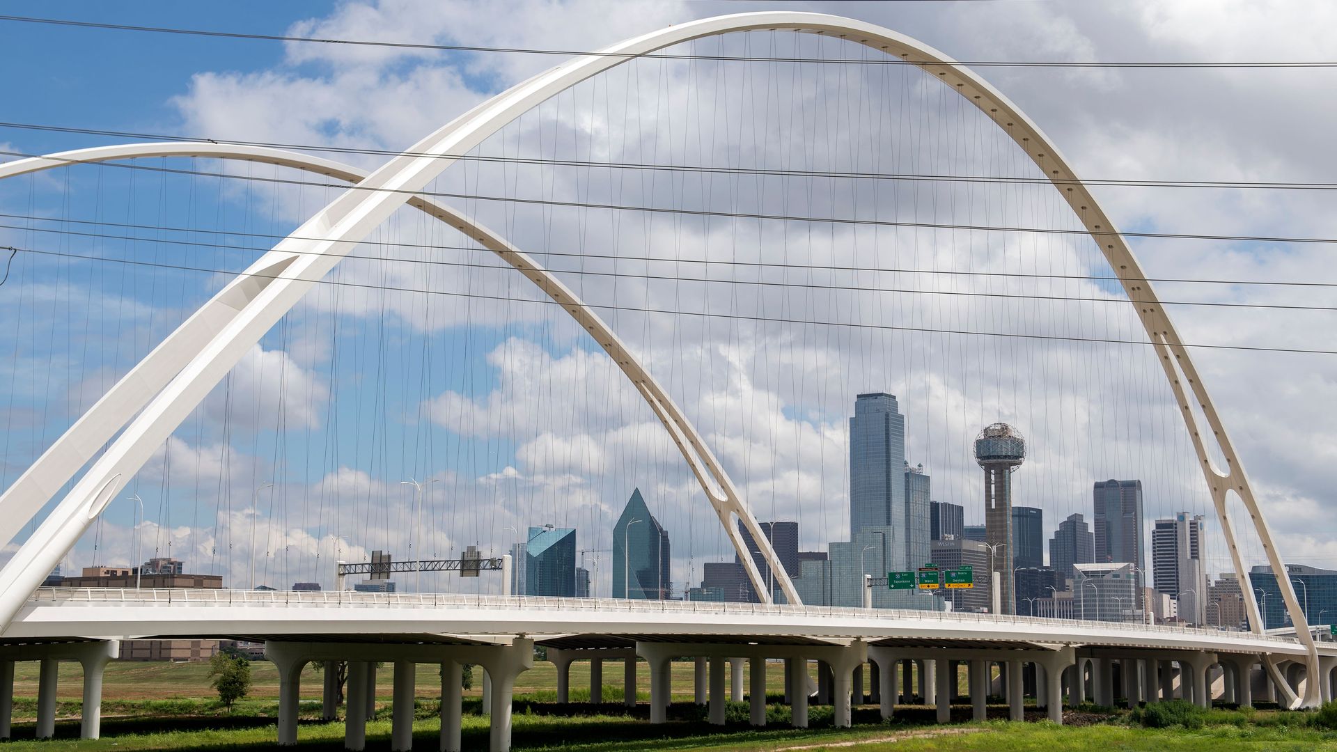 A photo of the Dallas skyline through a bridge 
