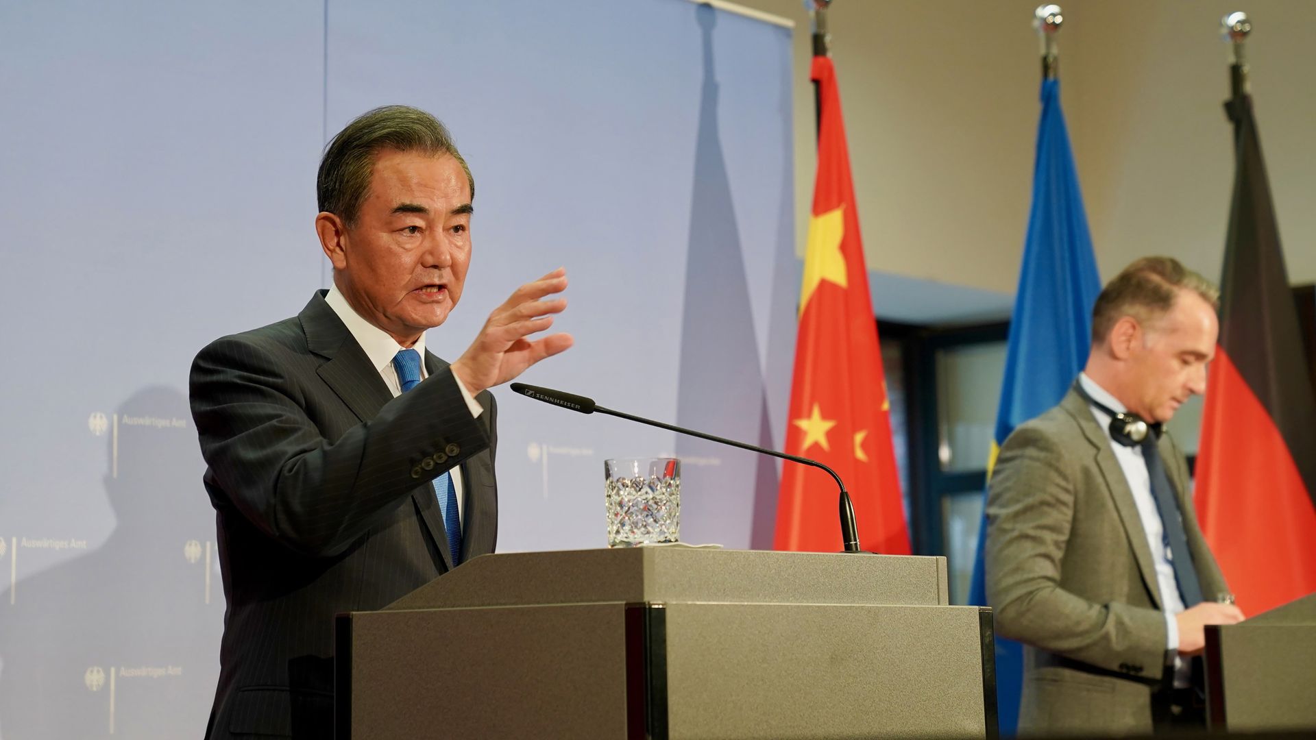 China's Foreign Minister Wang Yi stands in front of a microphone