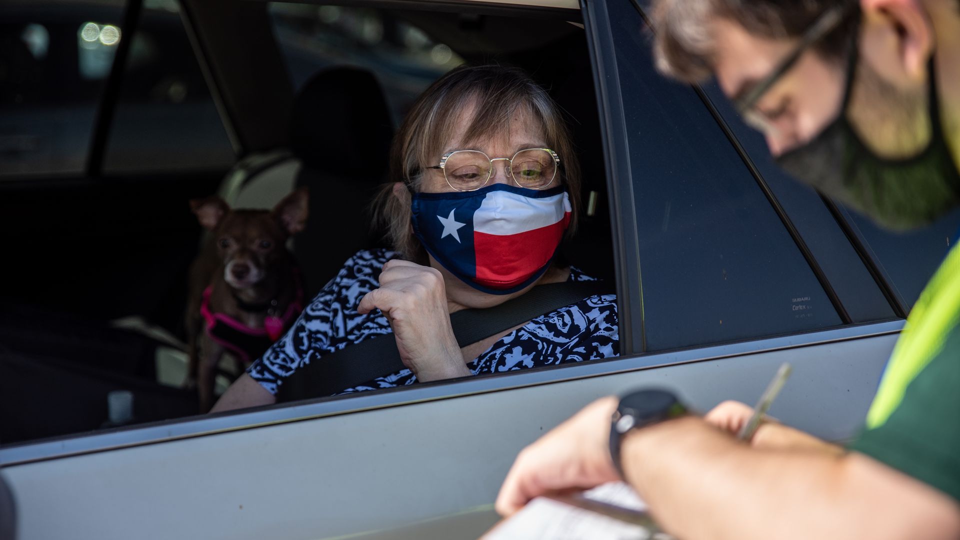 A poll worker helps a voter at a mail in ballot drop off in Texas.