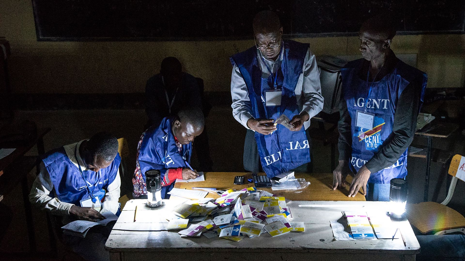 Independent National Electoral Commission (CENI) agents count votes during an electricity cut while watched by observers at Kiwele college in the Democratic Republic of Congo. 