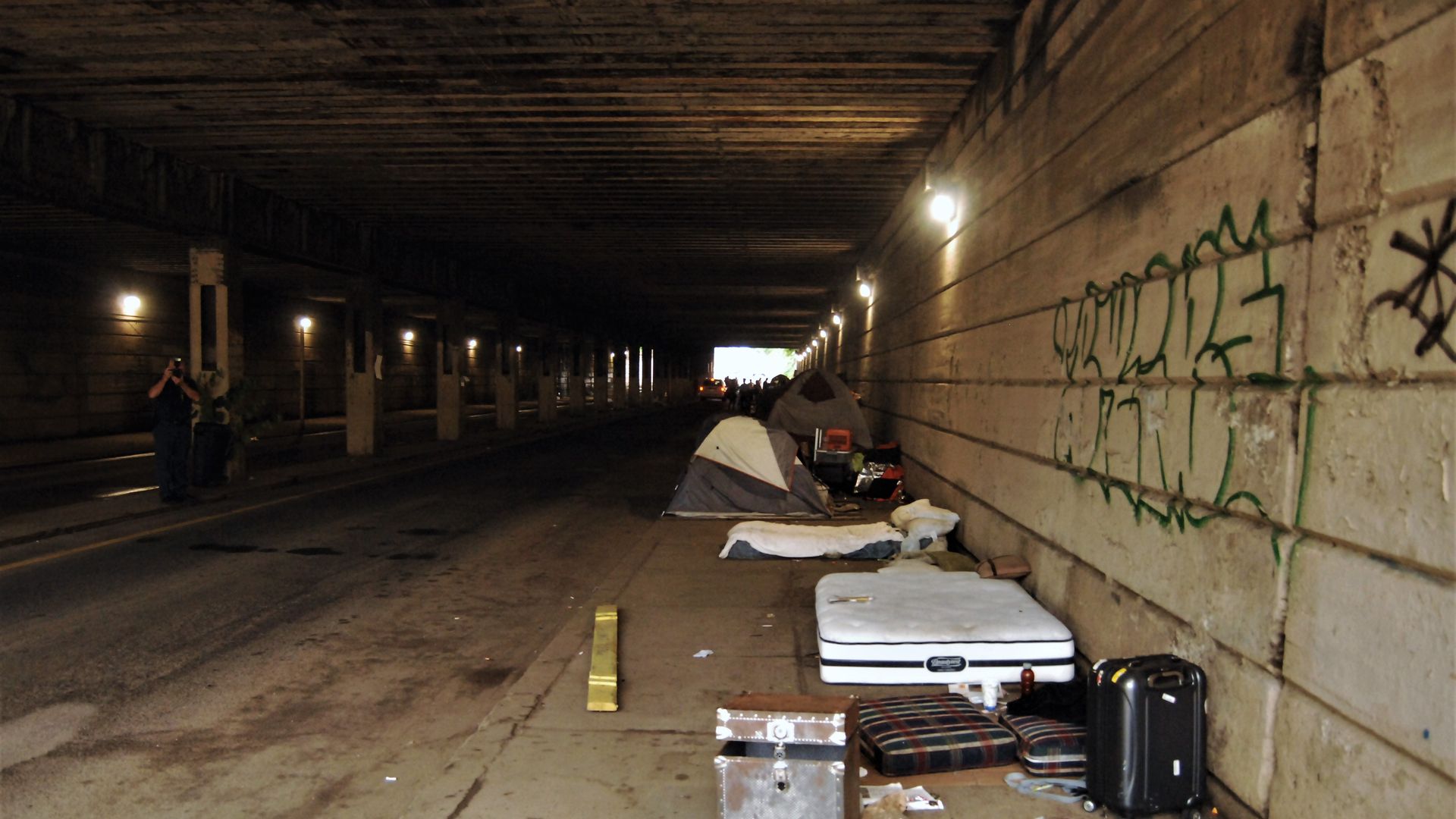 Makeshift beds for homeless people under a highway