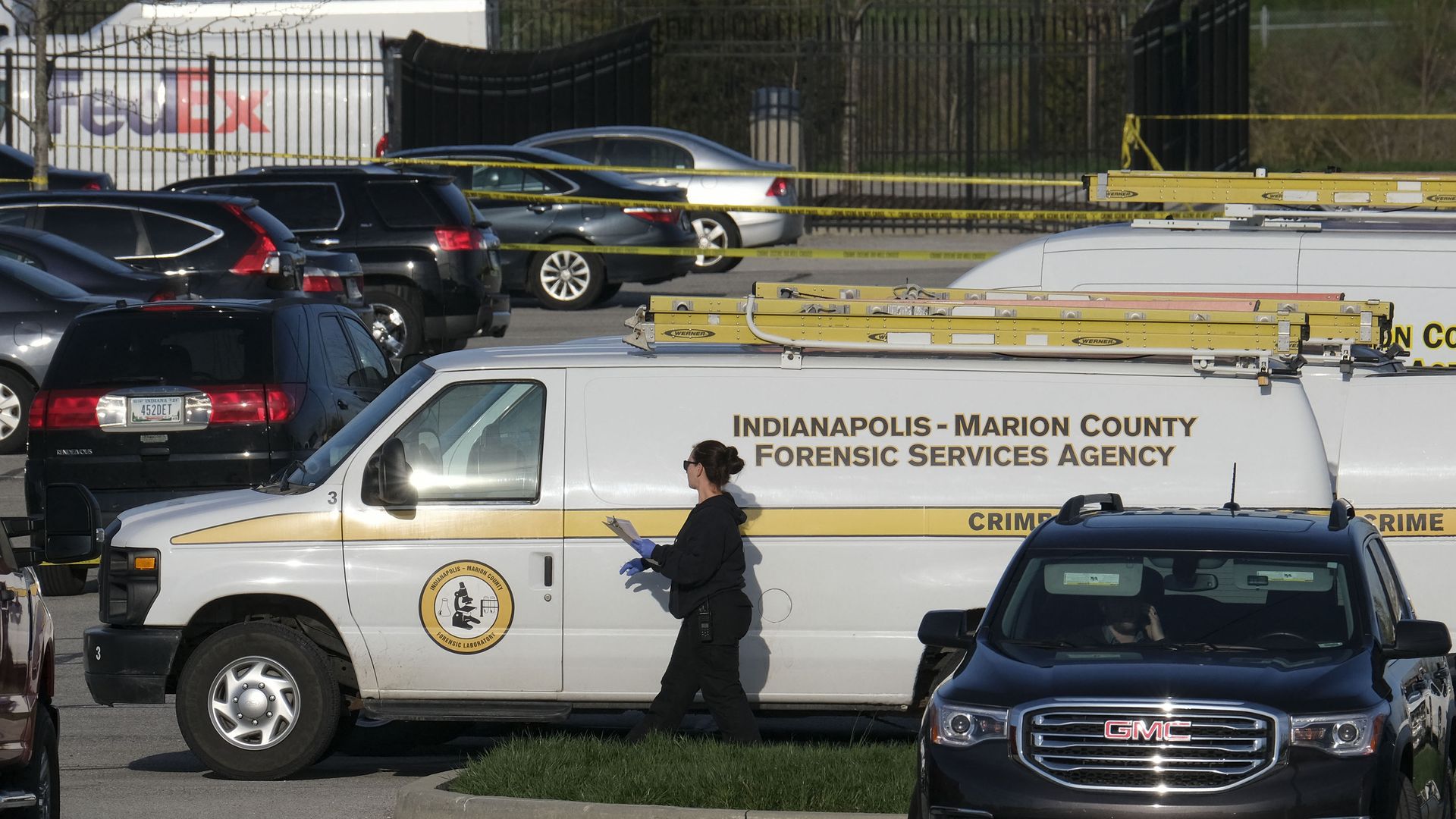  Marion County Forensic Services vehicles are parked at the site of a mass shooting at a FedEx facility in Indianapolis, Indiana on April 16