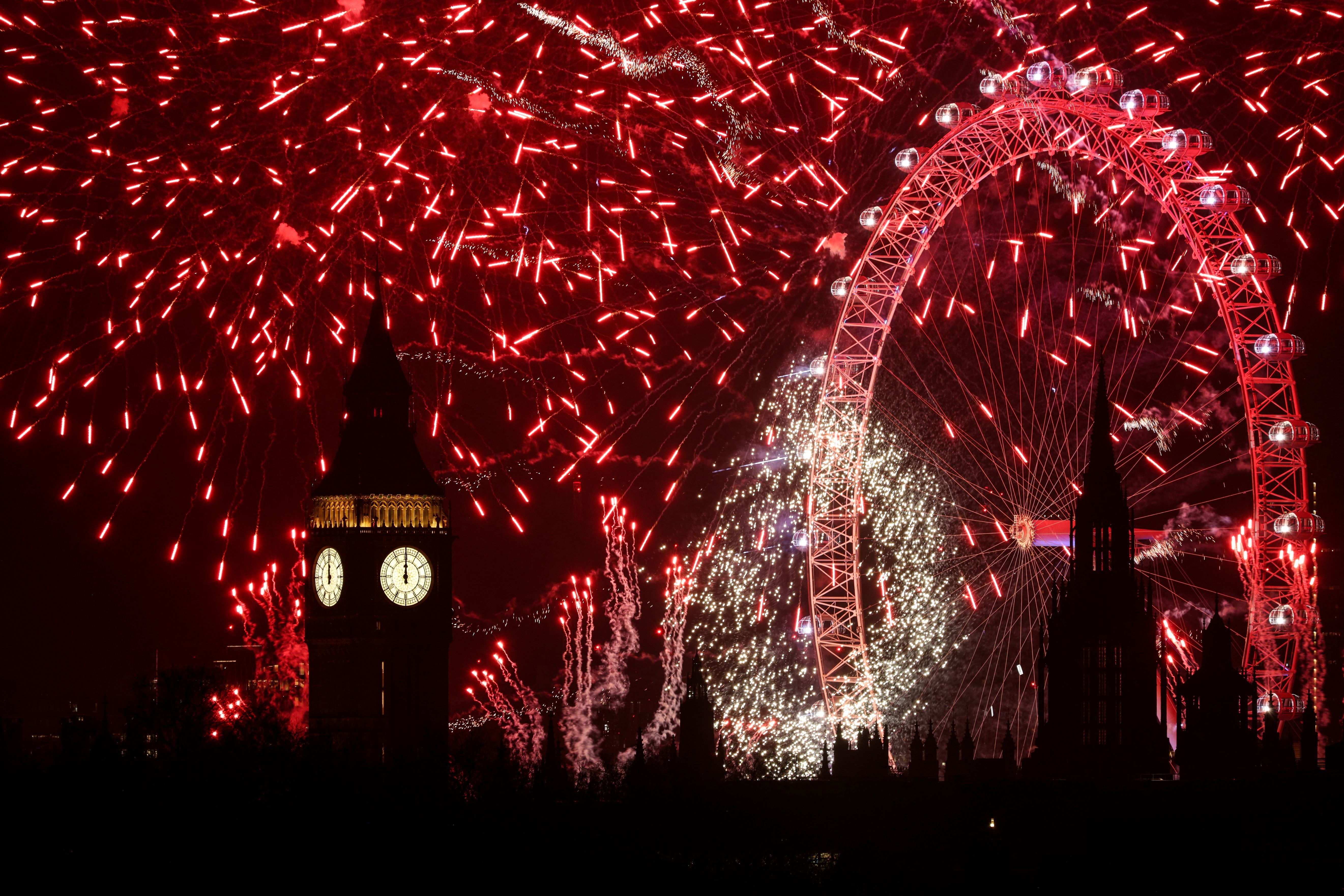 Fireworks explode in the sky around the London Eye and The Elizabeth Tower, commonly known by the name of the clock's bell, "Big Ben", at the Palace of Westminster, home to the Houses of Parliament, in central London, at midnight on January 1, 2025. 