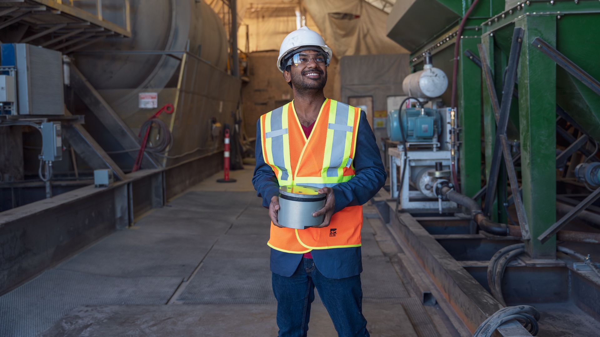 Carbon Upcycling's CEO Apoorv Sinha holding the company's first reactor in front of a production facility.