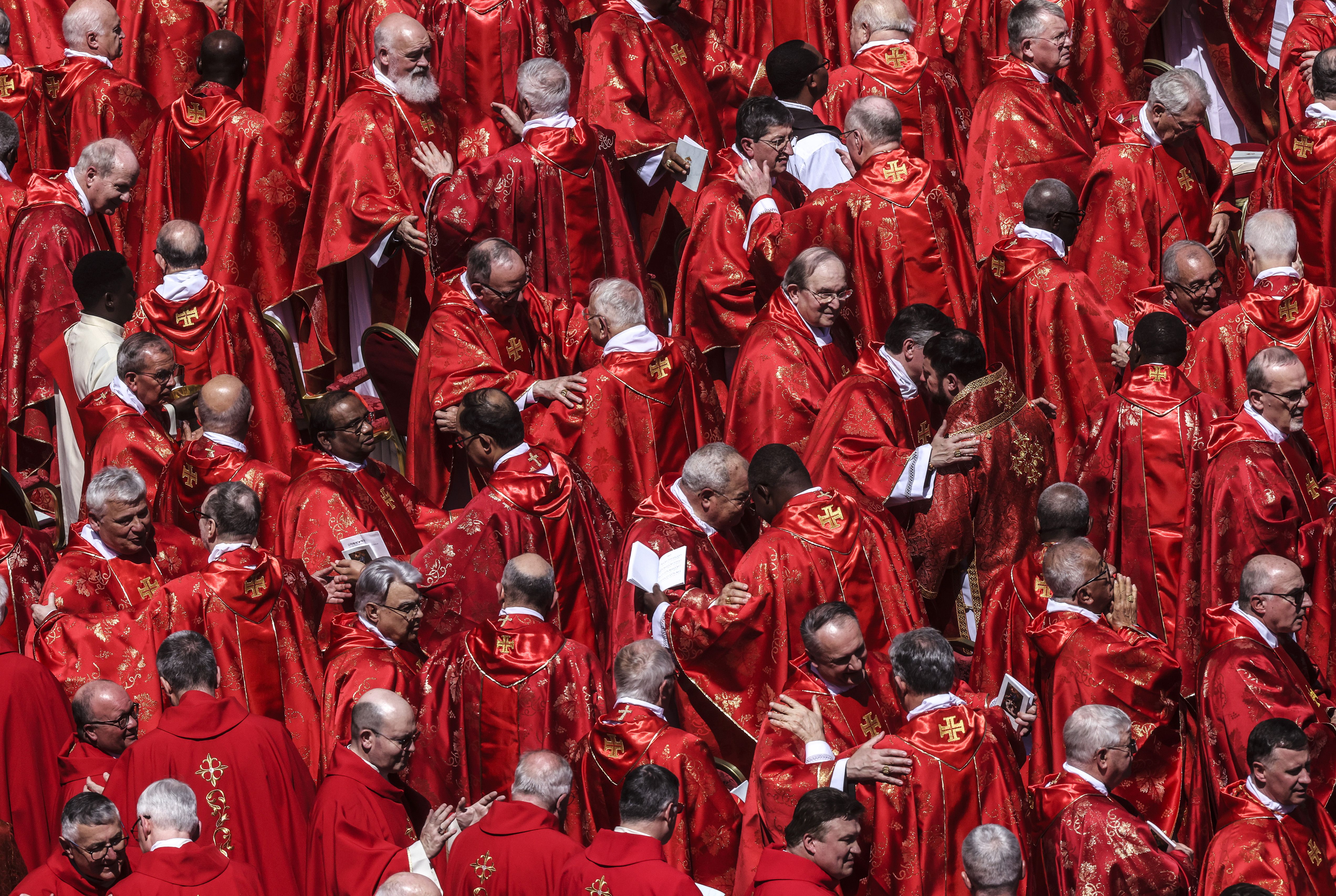 Cardinals hug dressed in red