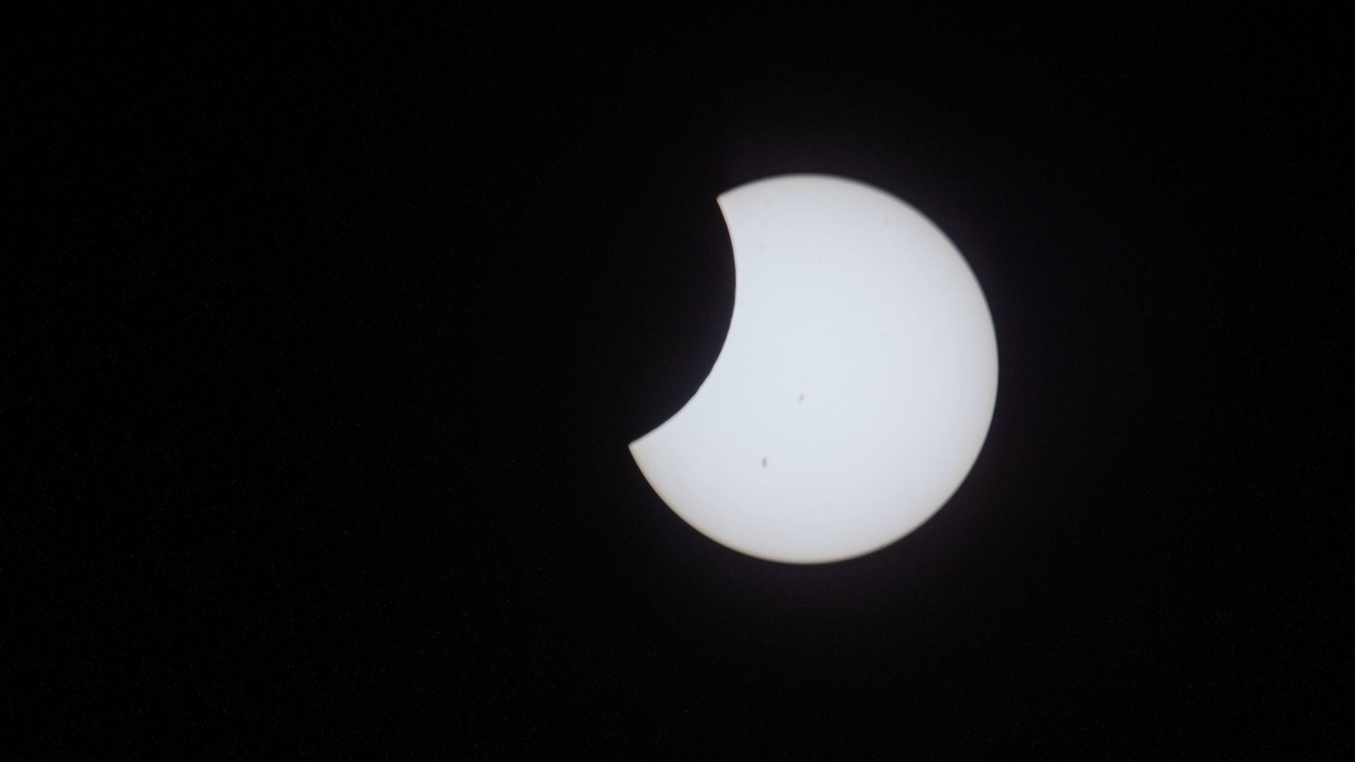 The Moon passes in front of the Sun during a partial solar eclipse as seen from the International Space Station