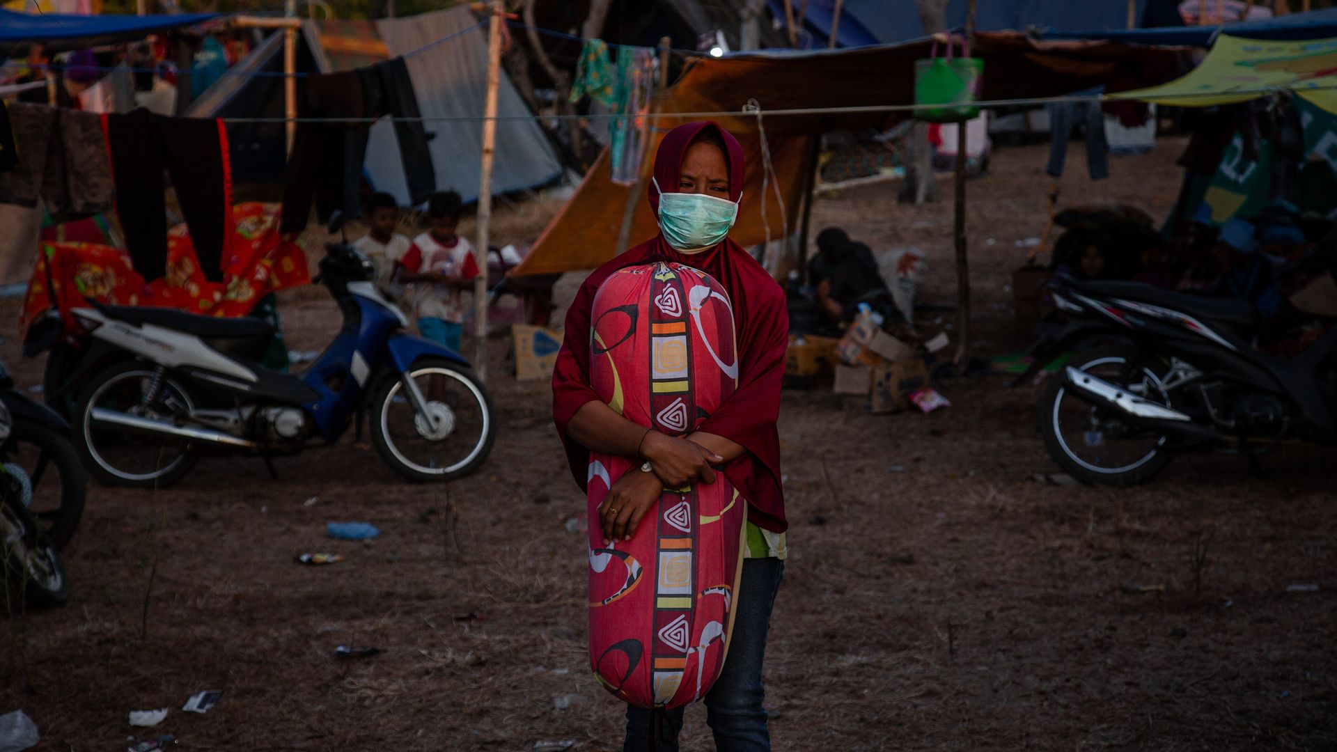 A girl standing in a temporary shelter.