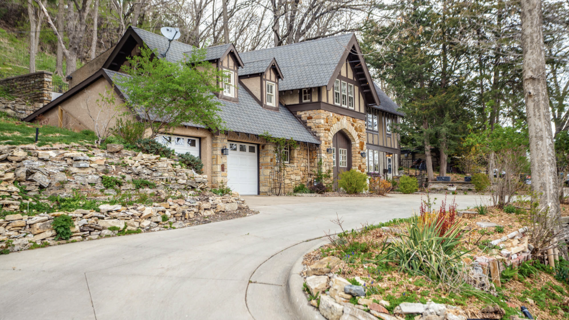 A brick home in Rochester with a wooded back yard and a rocky landscape 