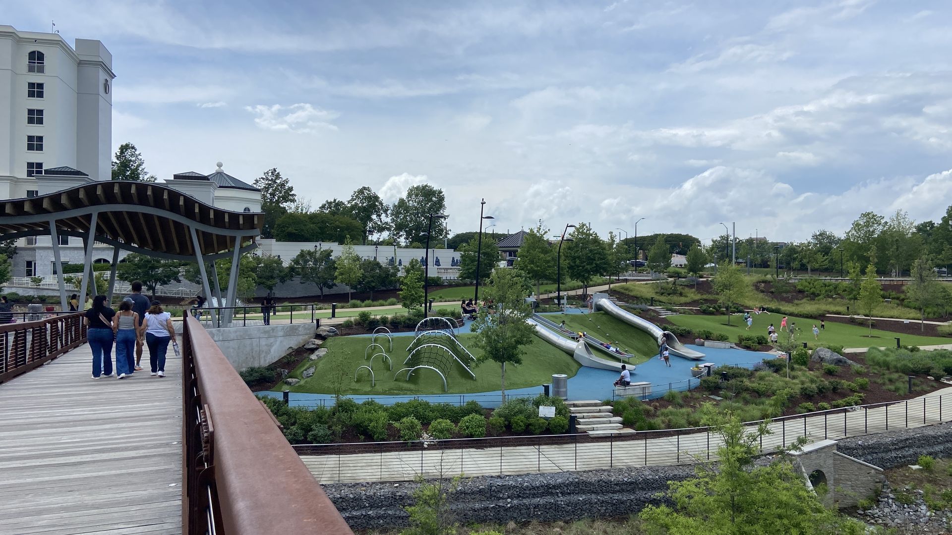 A pedestrian bridge in front of the Ballantyne hotel with a playground to the right. 