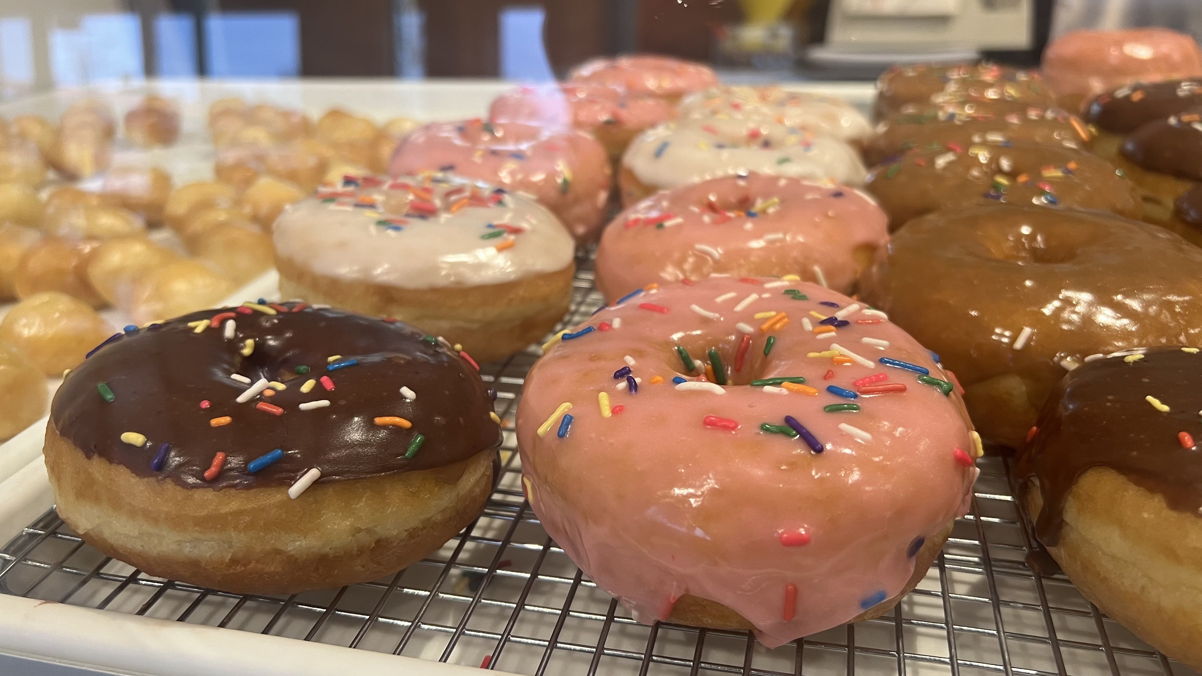 A display case full of raised frosted donuts