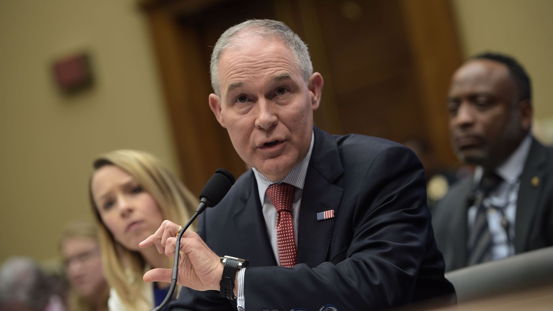 Scott Pruitt leans over a table while speaking during his hearing on Capitol Hill.