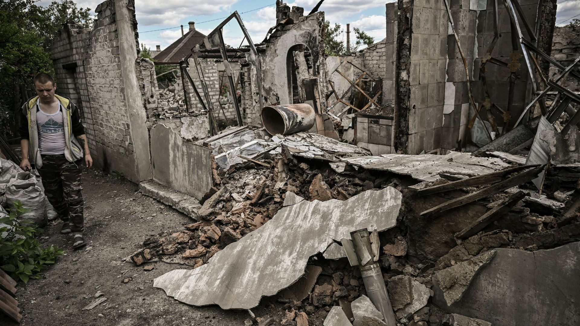 Ivan Sosnin, 19, walks next to his destroyed house in the city of Lysychansk at the eastern Ukrainian region of Donbas on June 7.