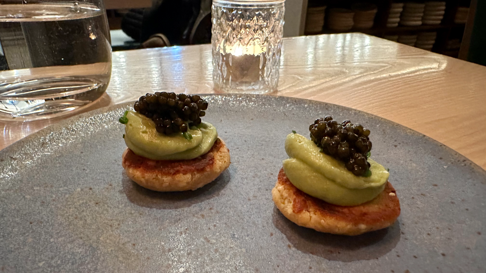 A photo of bite-sized pancakes topped with caviar