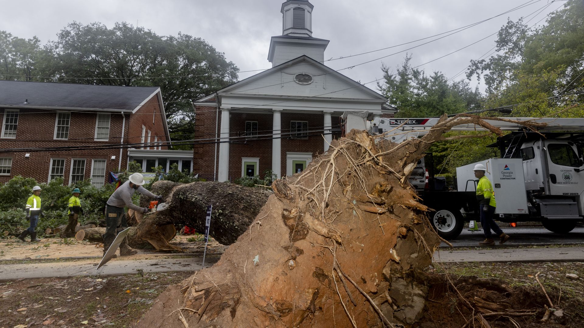 Crews work to remove a tree that fell in front of a church when Tropical Storm Helene moved through metro Atlanta.