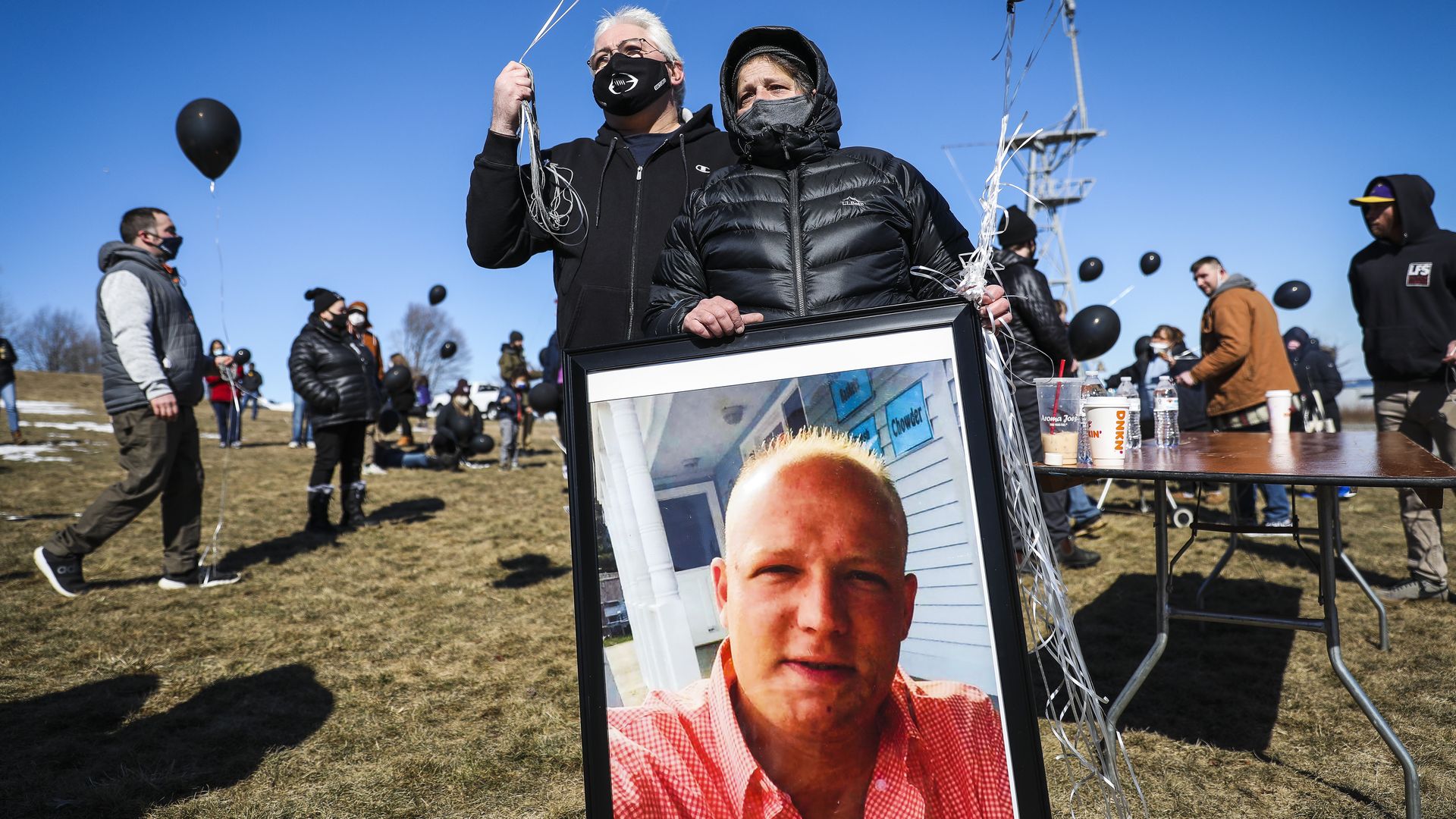 Roy Lee stands next to his girlfriend Trina Mills' as she holds onto a large photograph of her son Shane Robert Mills while attending a day to honor those who have died due to accidental overdoses.