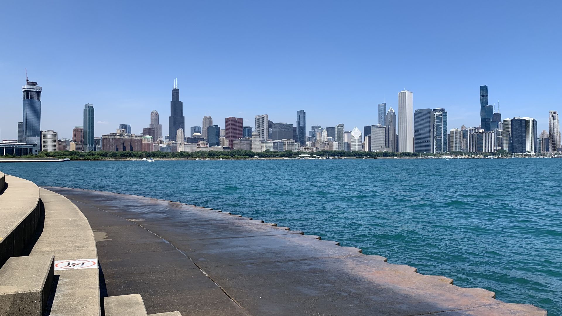Photo of a skyline of skyscrapers with a body of water in front of it.