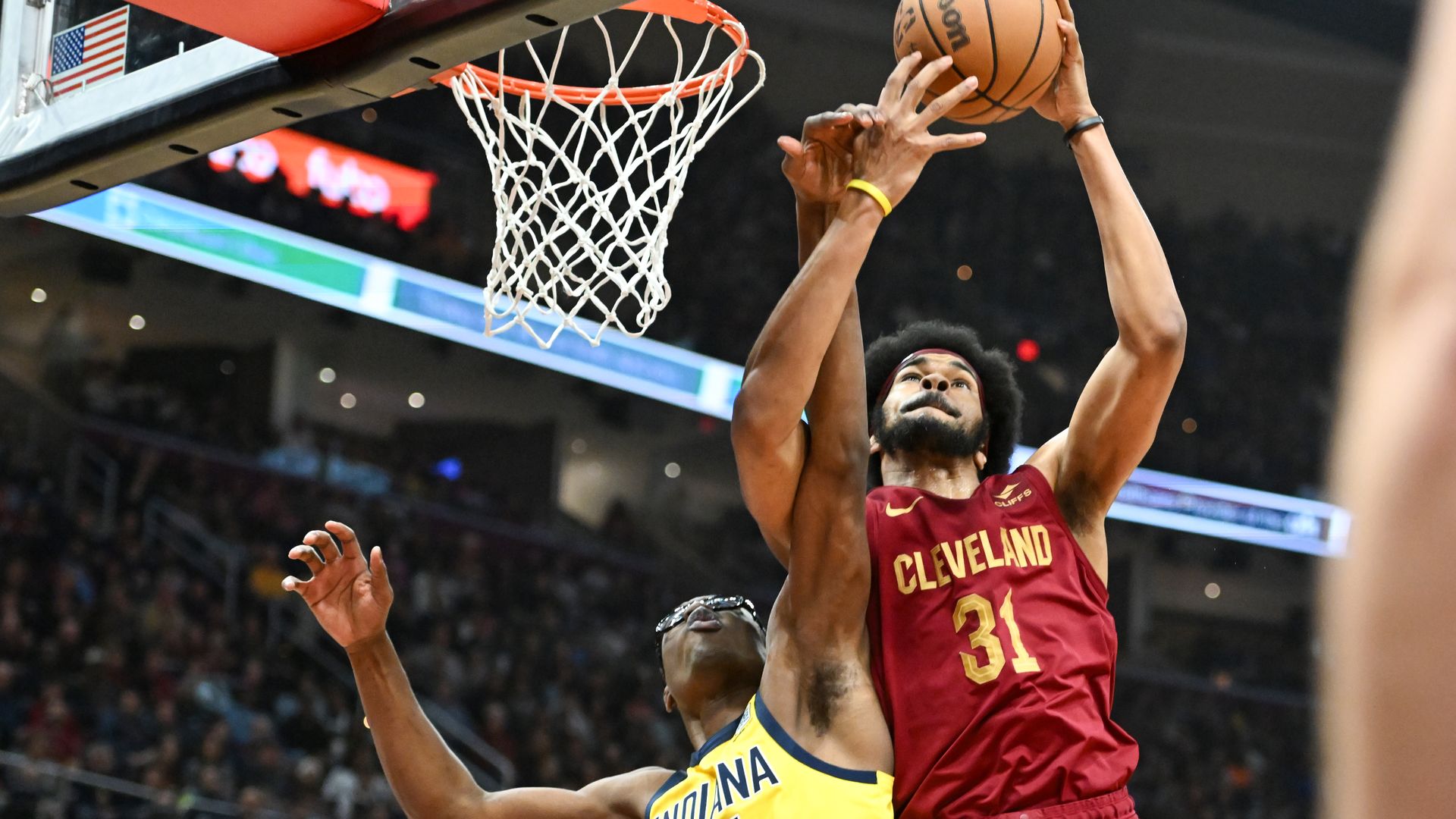 A photo of the Cavs' Jarrett Allen (red jersey) grabbing an offensive rebound in a basketball game
