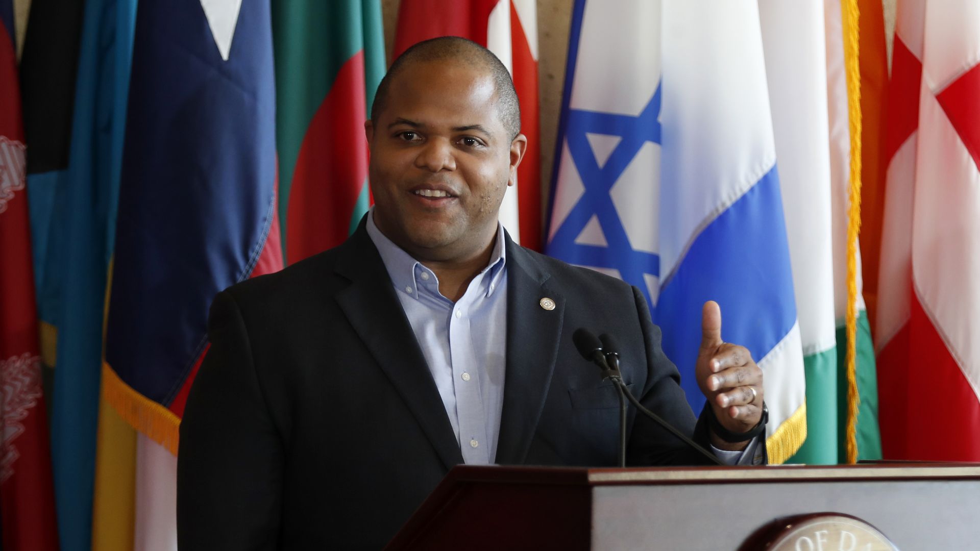 Mayor Eric Johnson in front of flags