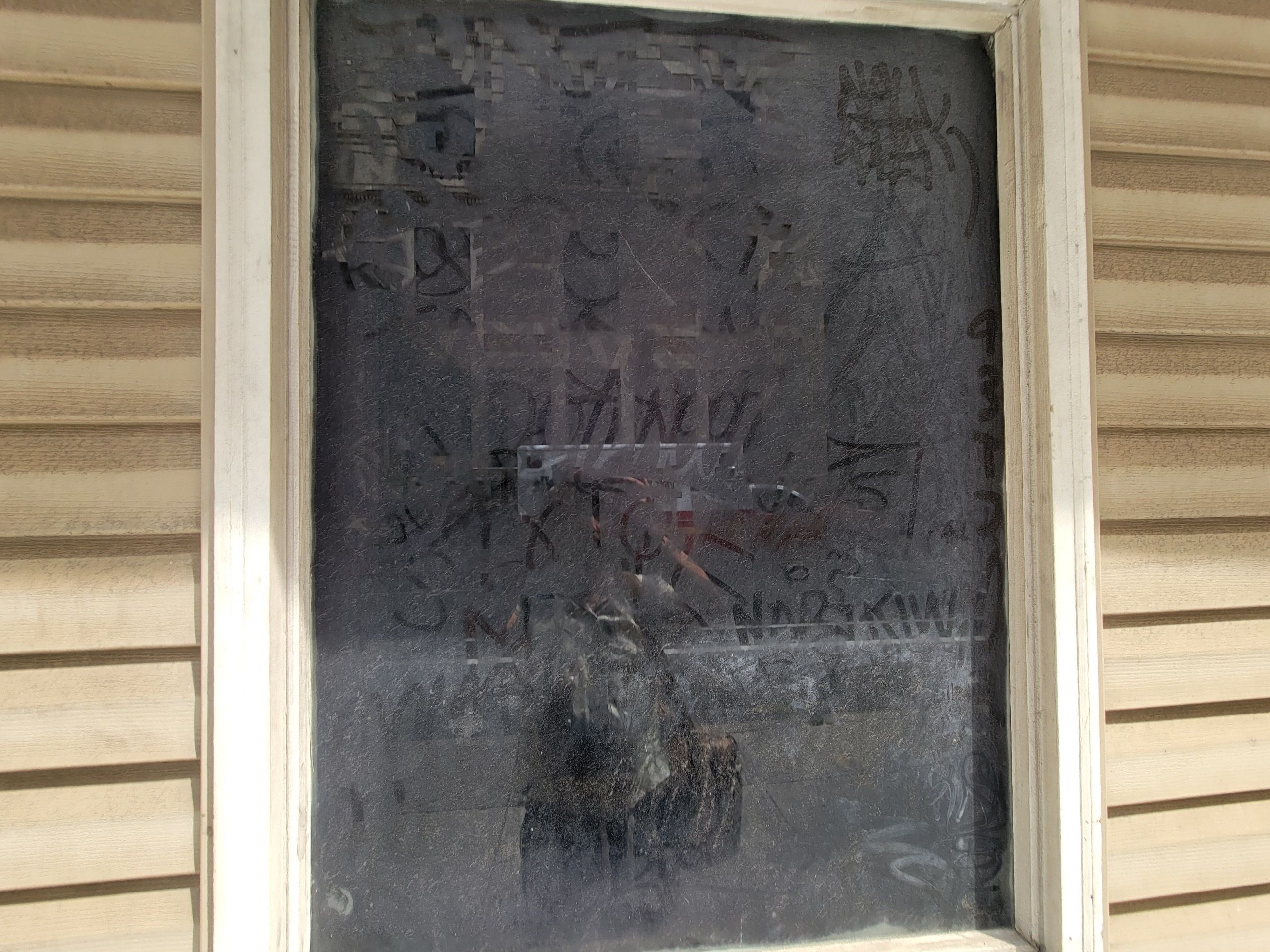 Foggy, uncleaned windows with scrawled messages in the dust.