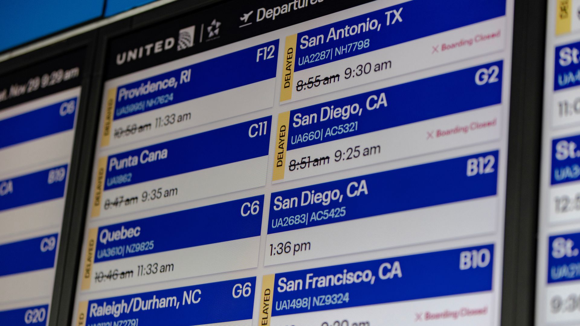 Flight information board at Chicago’s O’Hare International Airport displaying multiple flight delays during a winter storm.