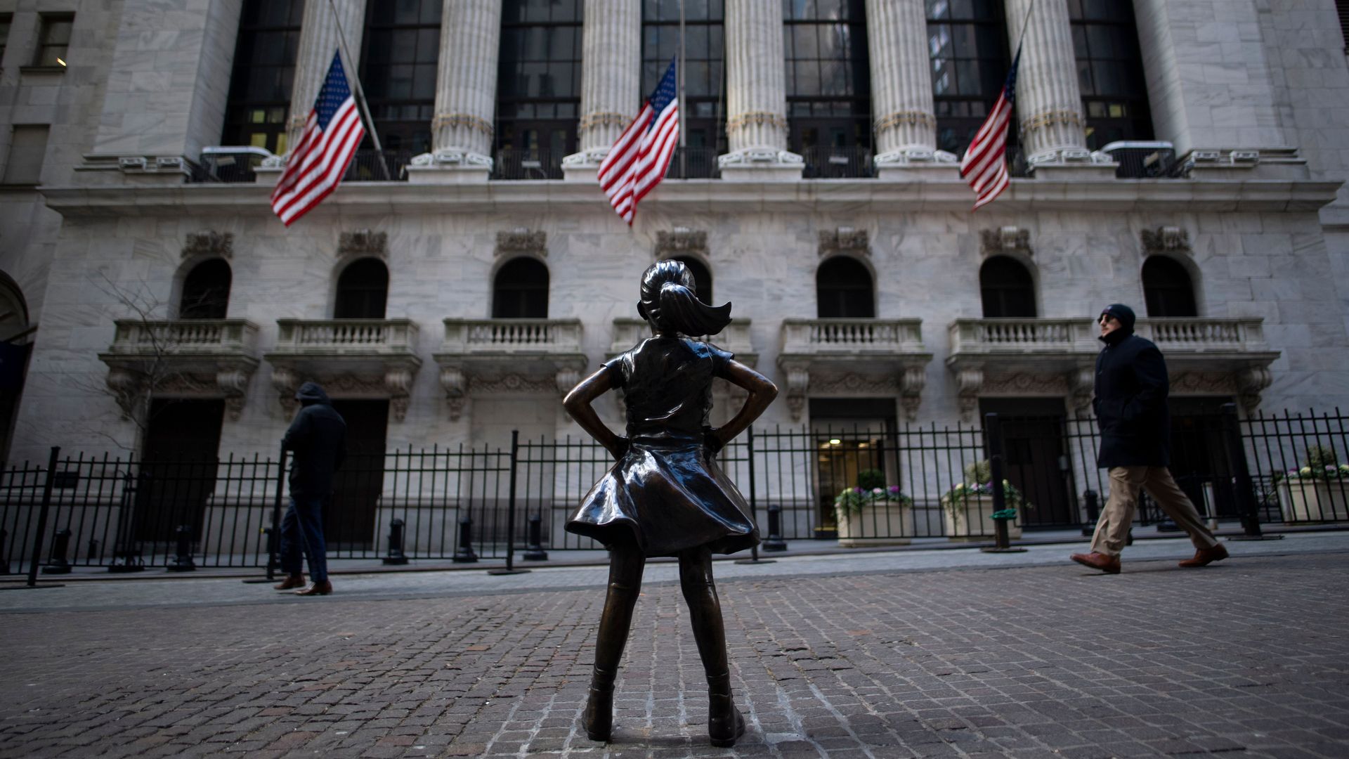 The fearless girl statue at the New York Stock Exchange on an overcast day. 