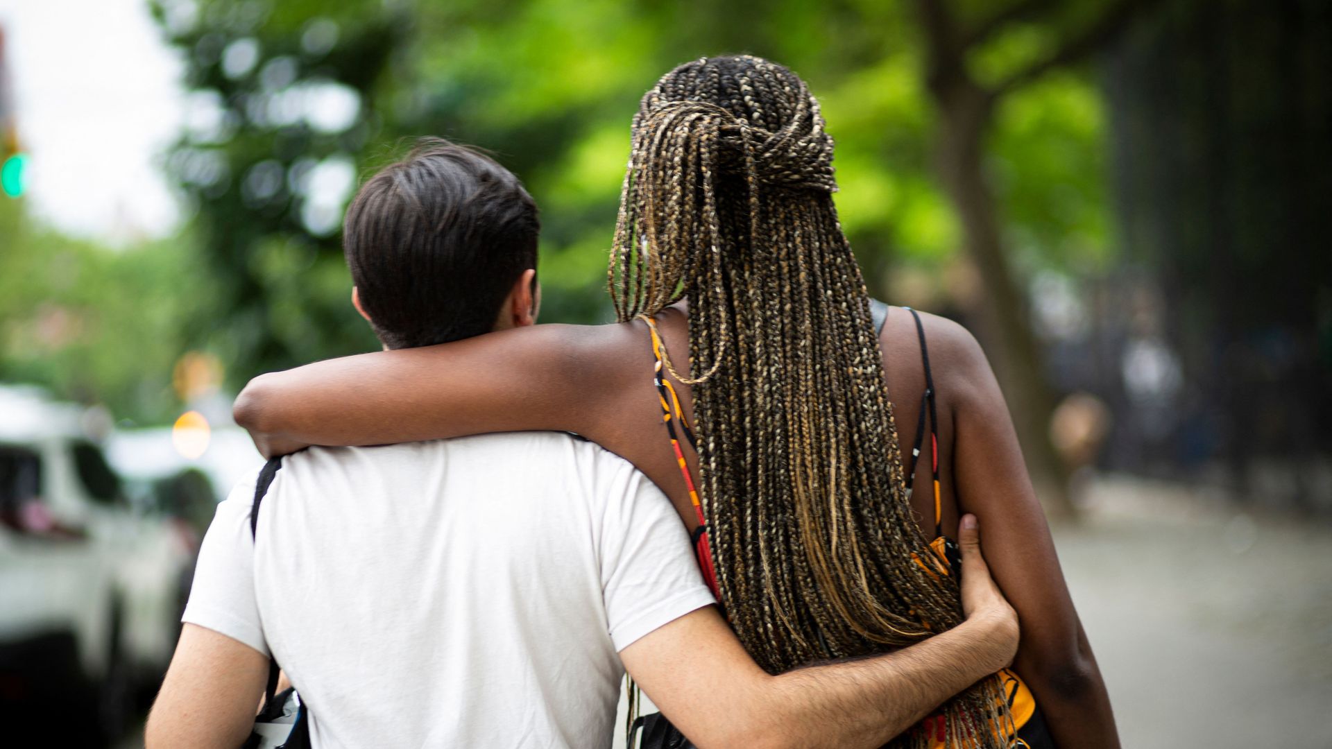 A man and a woman embrace each other as they walk during the 28th annual Juneteenth celebration in the Harlem neighborhood of New York.