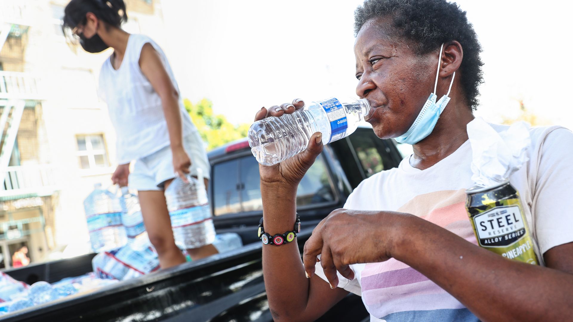 : A member of the Skid Row community drinks water distributed by volunteers with Water Drop LA on September 4.