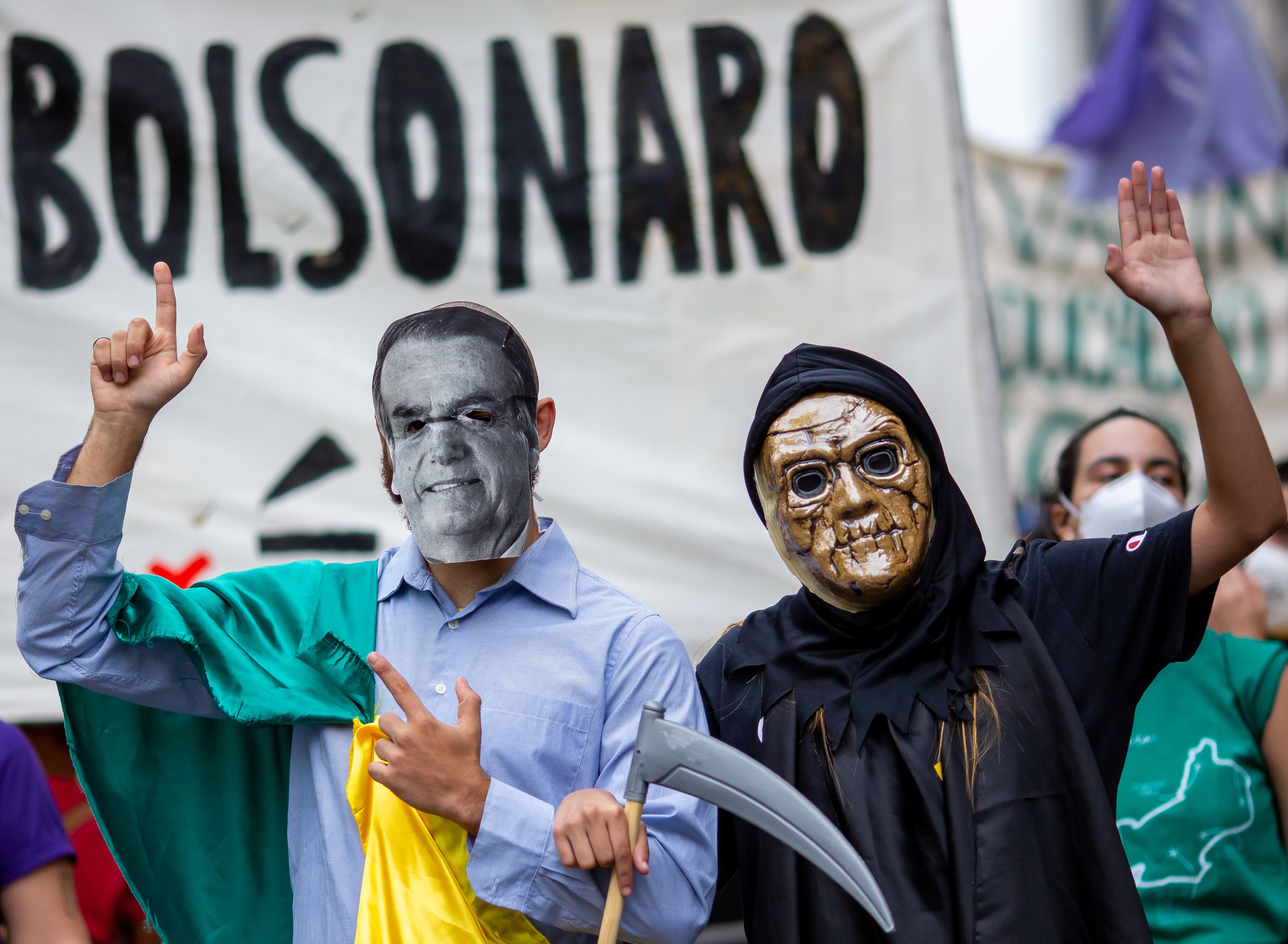 Demonstrators wear a costume depicting death and the picture of Jair Bolsonaro during a protest against Bolsonaro's administration on June 19, 2021 in Rio de Janeiro, Brazil. 