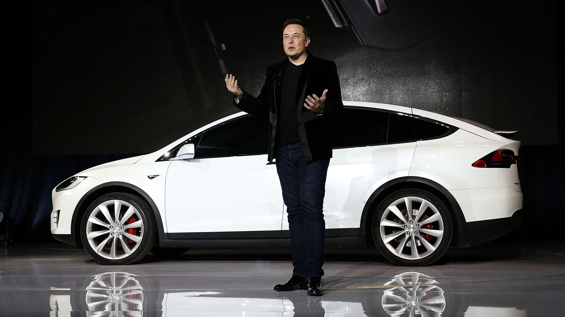 Elon Musk in front of Tesla car