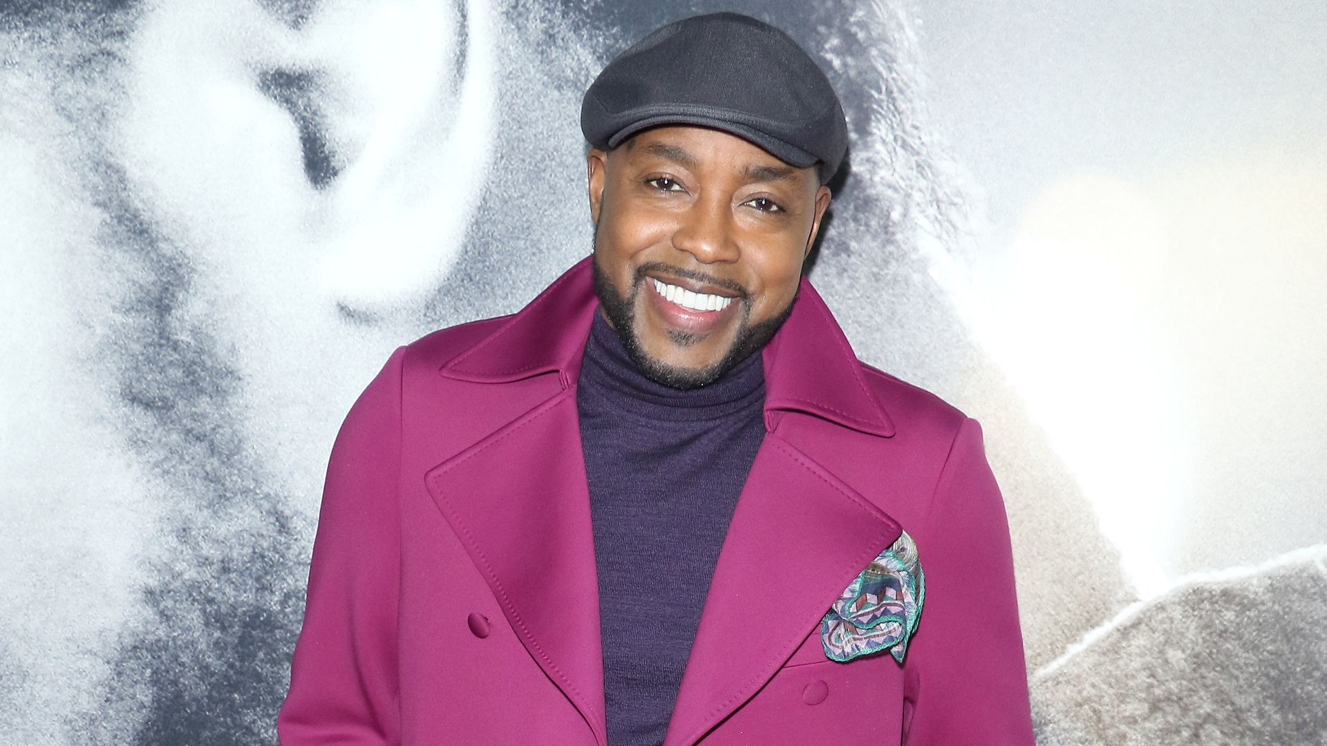 Will Packer wearing a pink coat on the red carpet